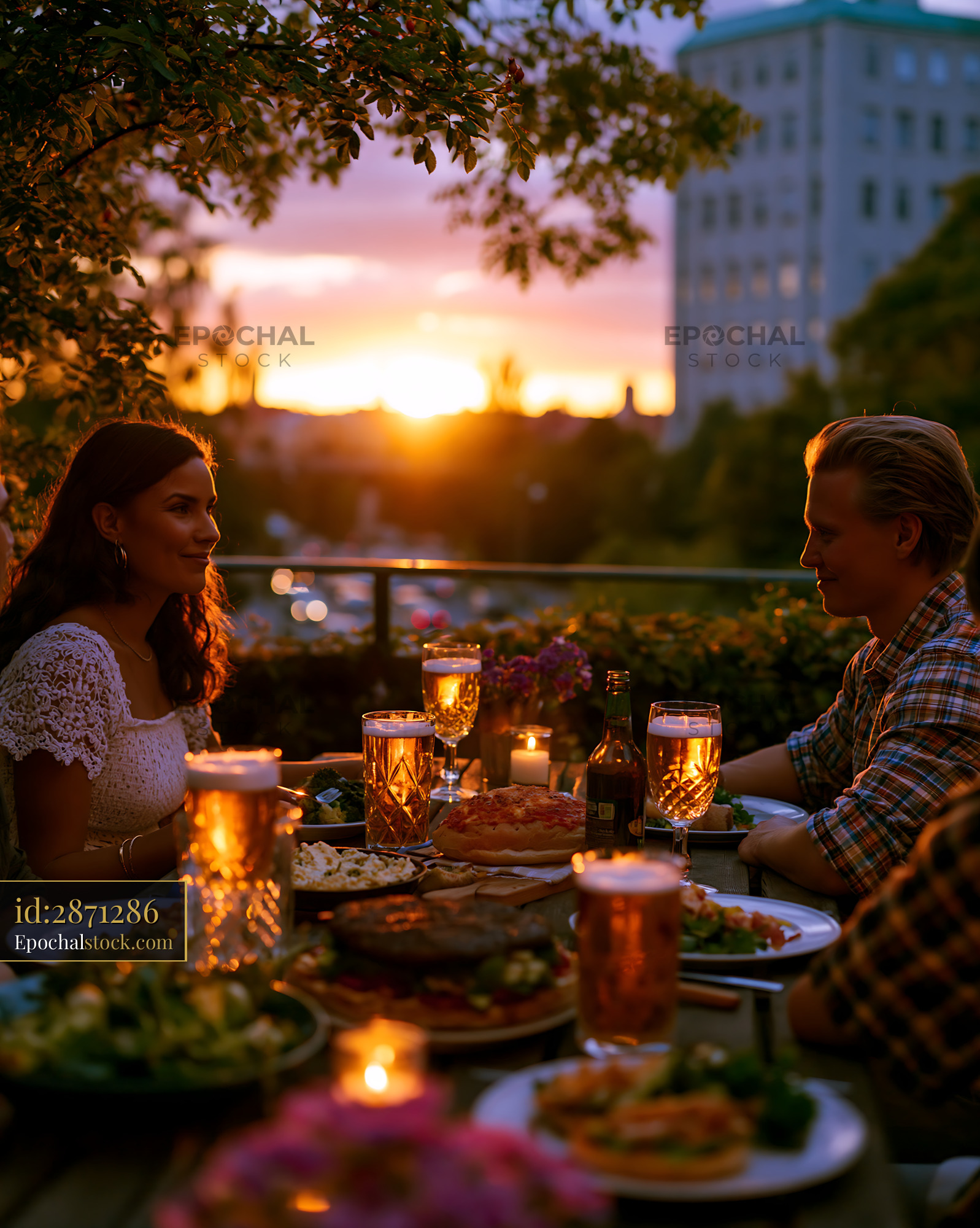Watermarked full-resolution preview of Couple enjoys dinner with drinks during sunset at outdoor table