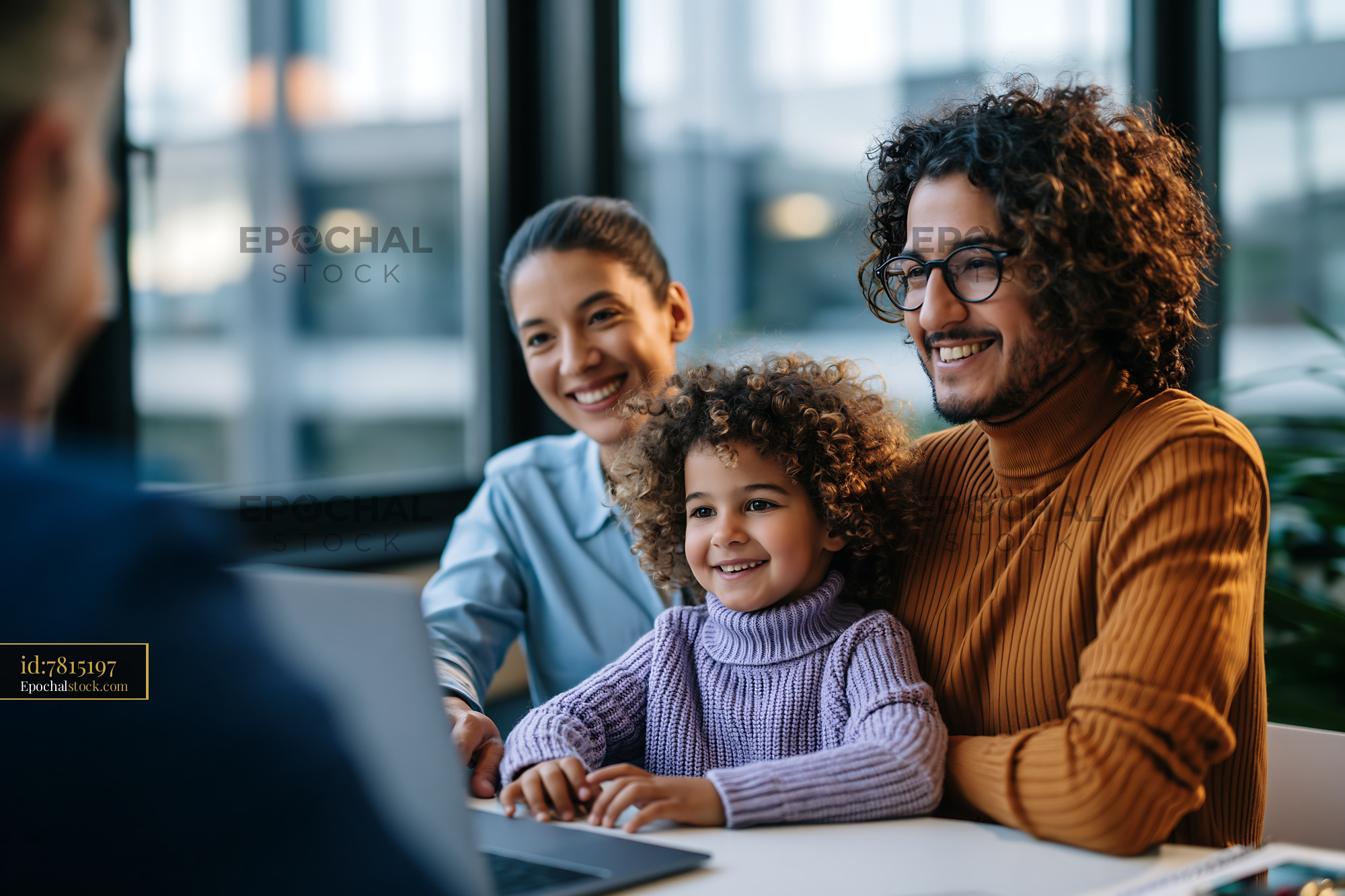 Watermarked full-resolution preview of Family working together at a table with a laptop in a bright room