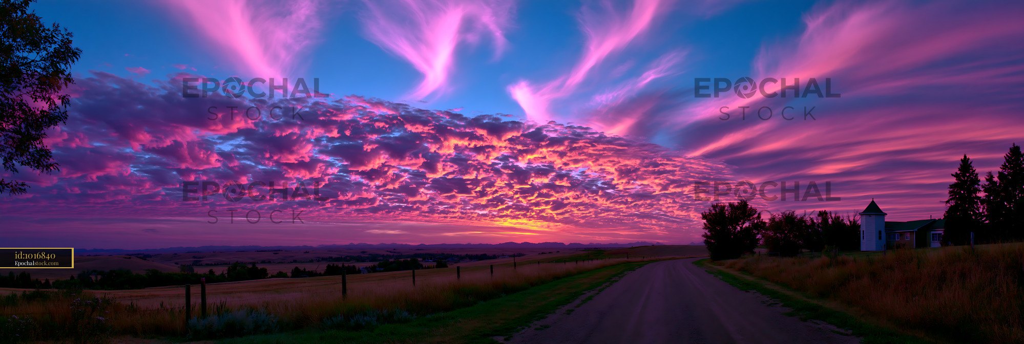 Watermarked full-resolution preview of Colorful sunset over a rural landscape with clouds and road