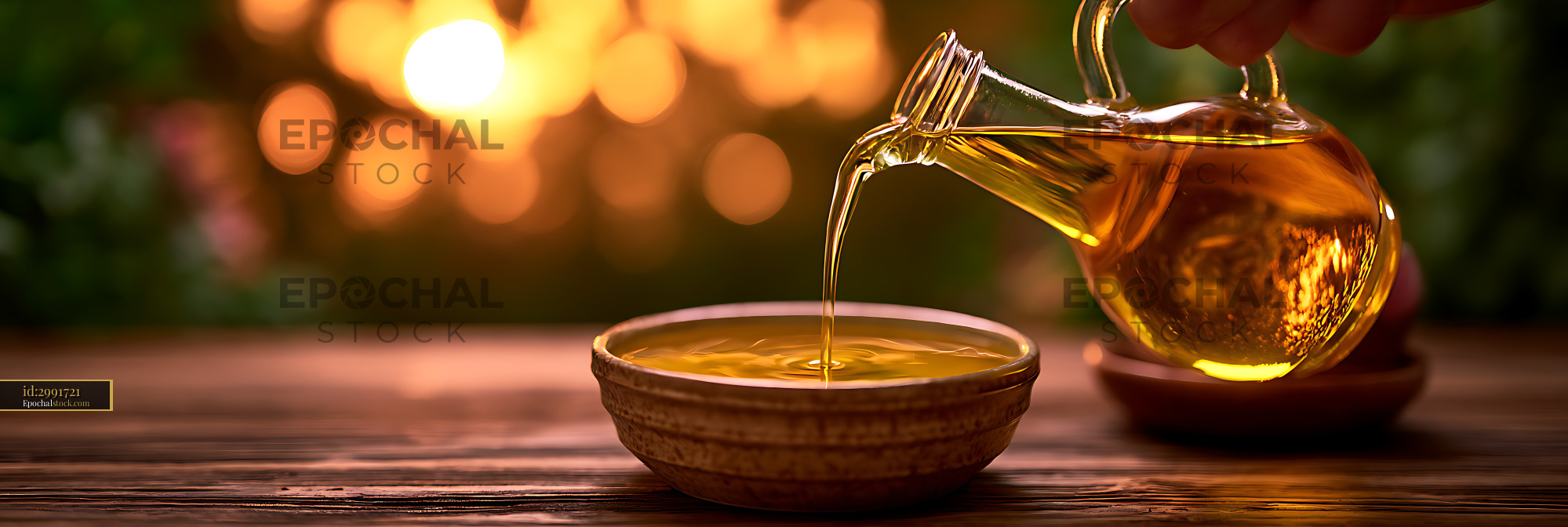 Watermarked full-resolution preview of Golden oil pouring into a bowl in warm sunset light