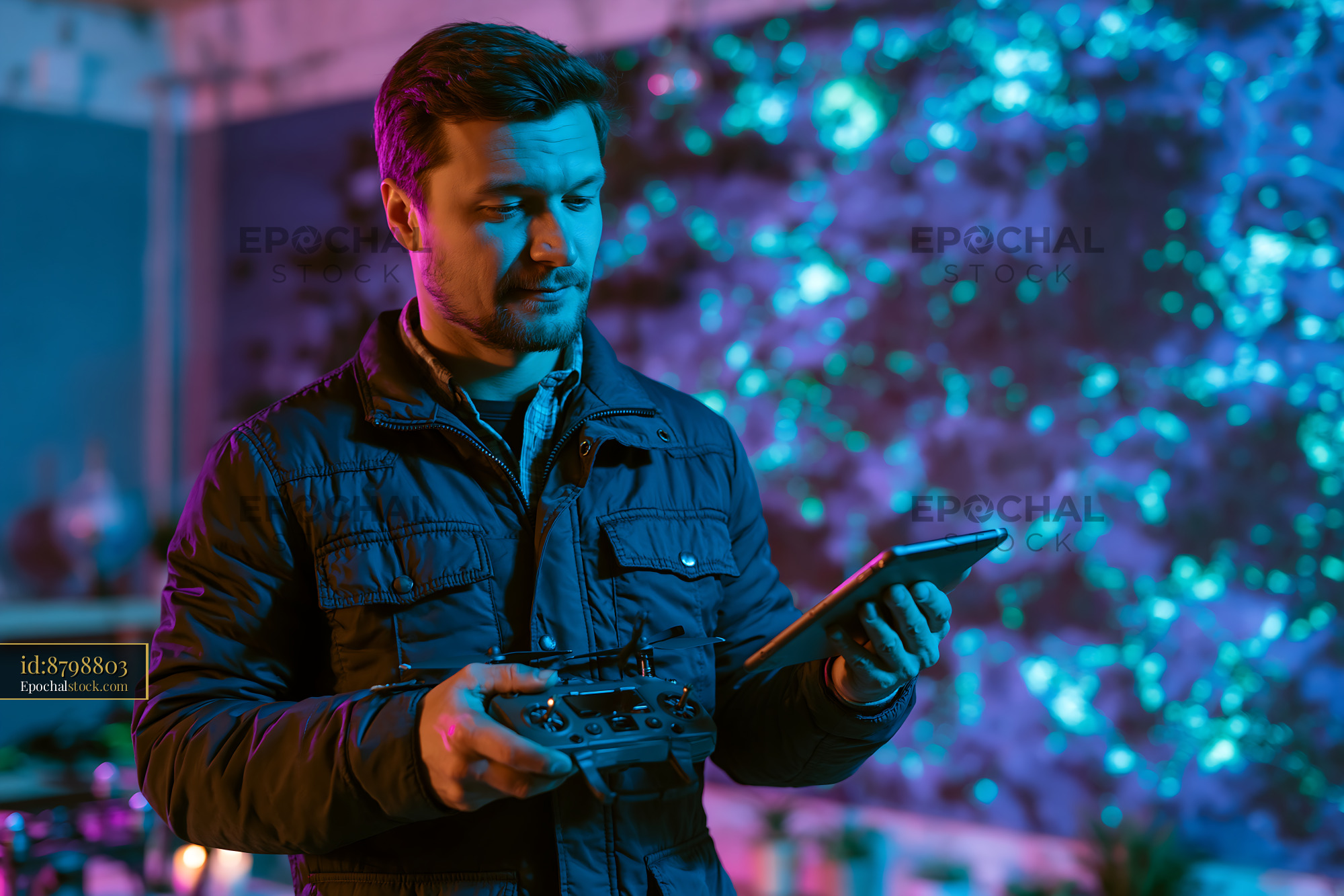 Watermarked full-resolution preview of Man controls drone with remote in colorful setting