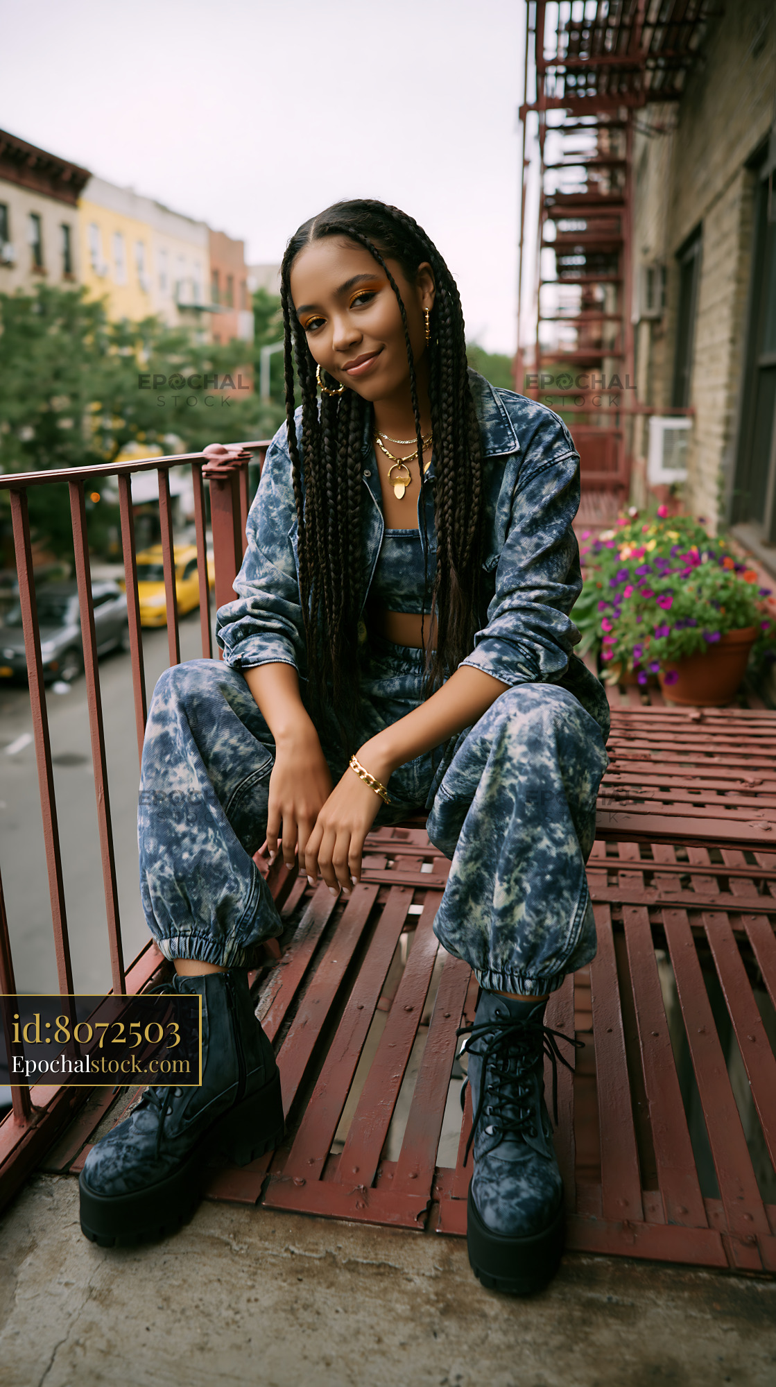 Watermarked full-resolution preview of Woman sitting on balcony wearing blue outfit and boots