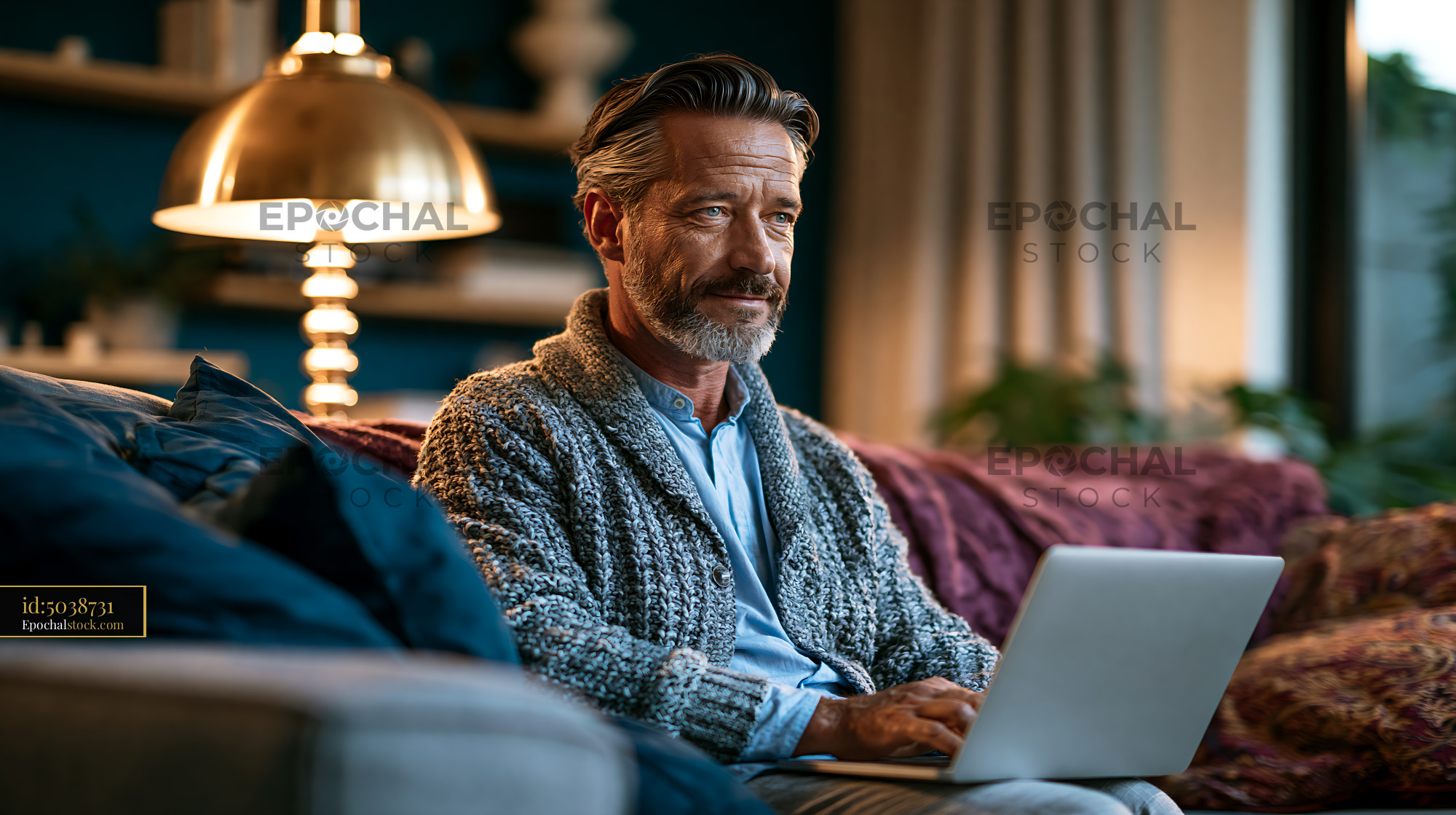 Watermarked full-resolution preview of Man working on a laptop at home in cozy living room setting