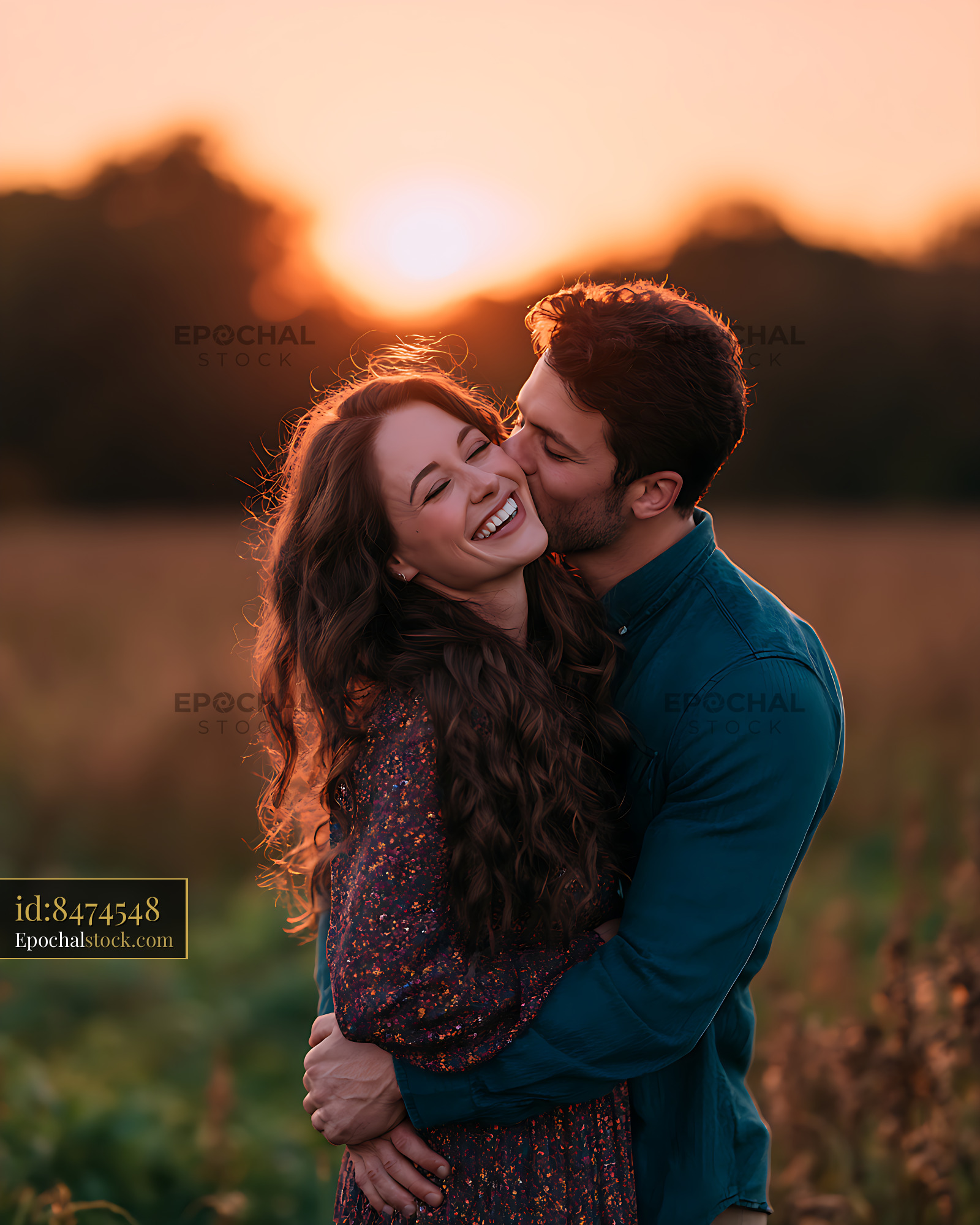 Watermarked full-resolution preview of Happy couple sharing a kiss in a sunlit field