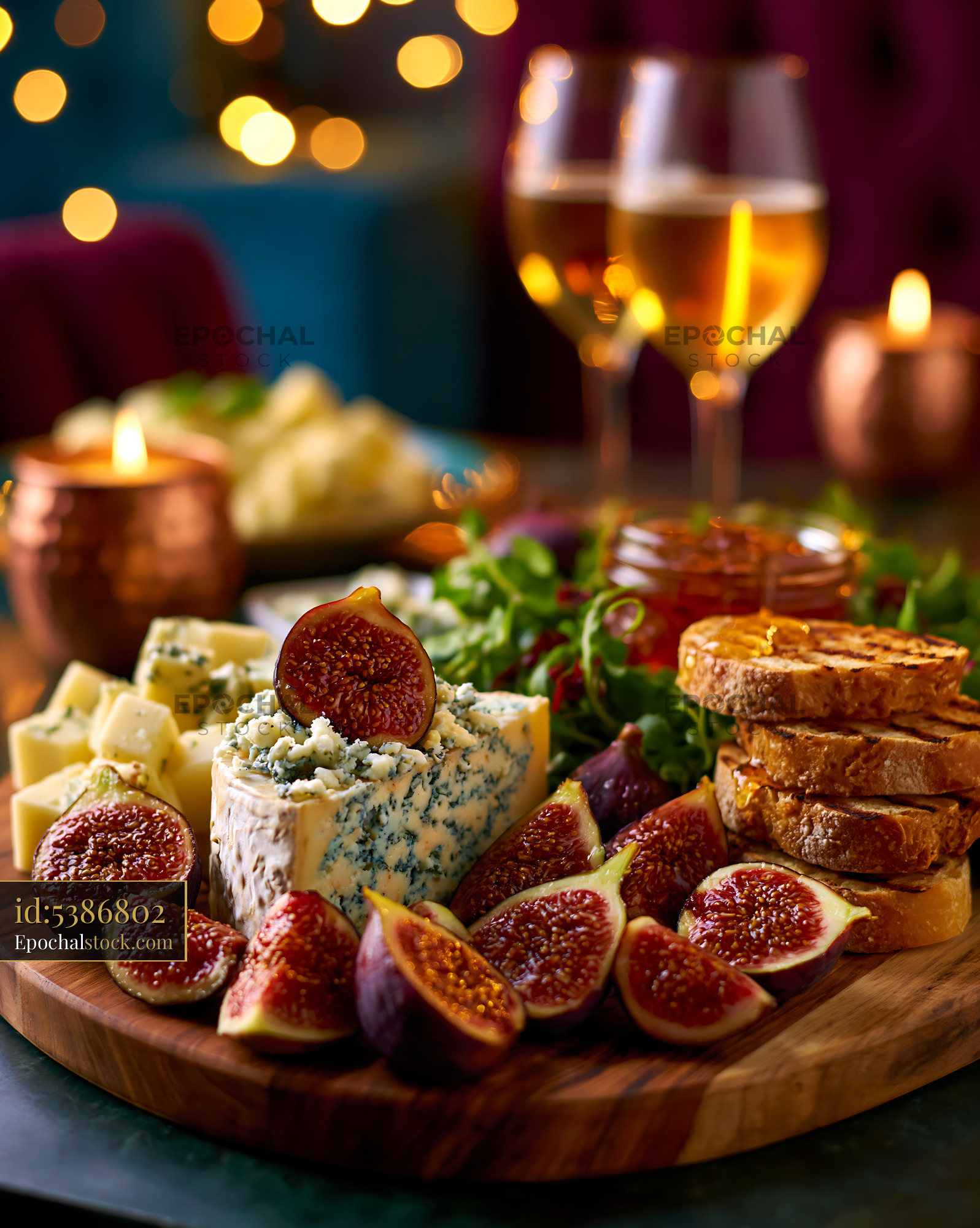 Watermarked full-resolution preview of Cheese platter with dried figs, bread and drinks on a table