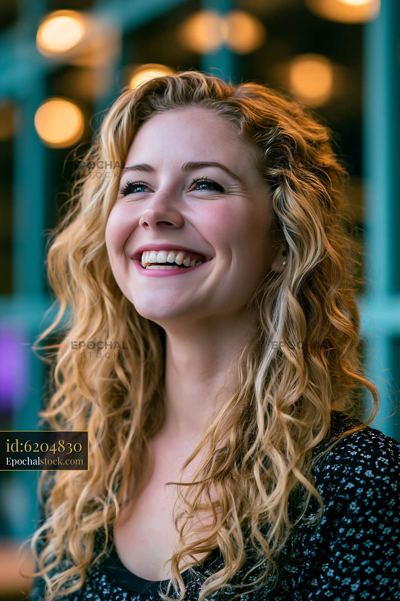 Watermarked full-resolution preview of Woman with curly hair smiling in a cafe setting
