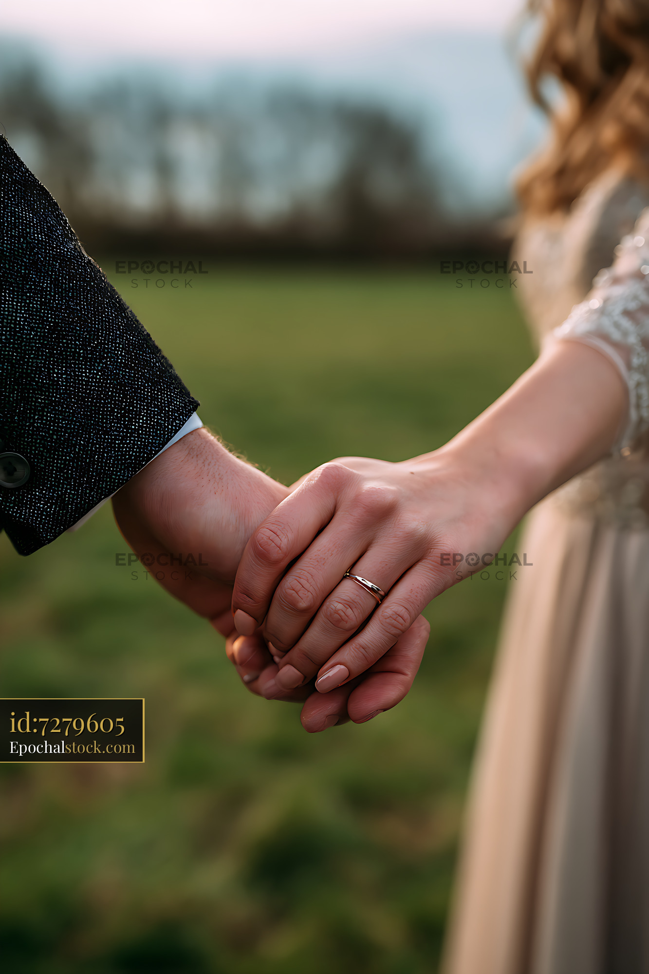 Watermarked full-resolution preview of Couple Holding Hands in a Green Outdoor Setting