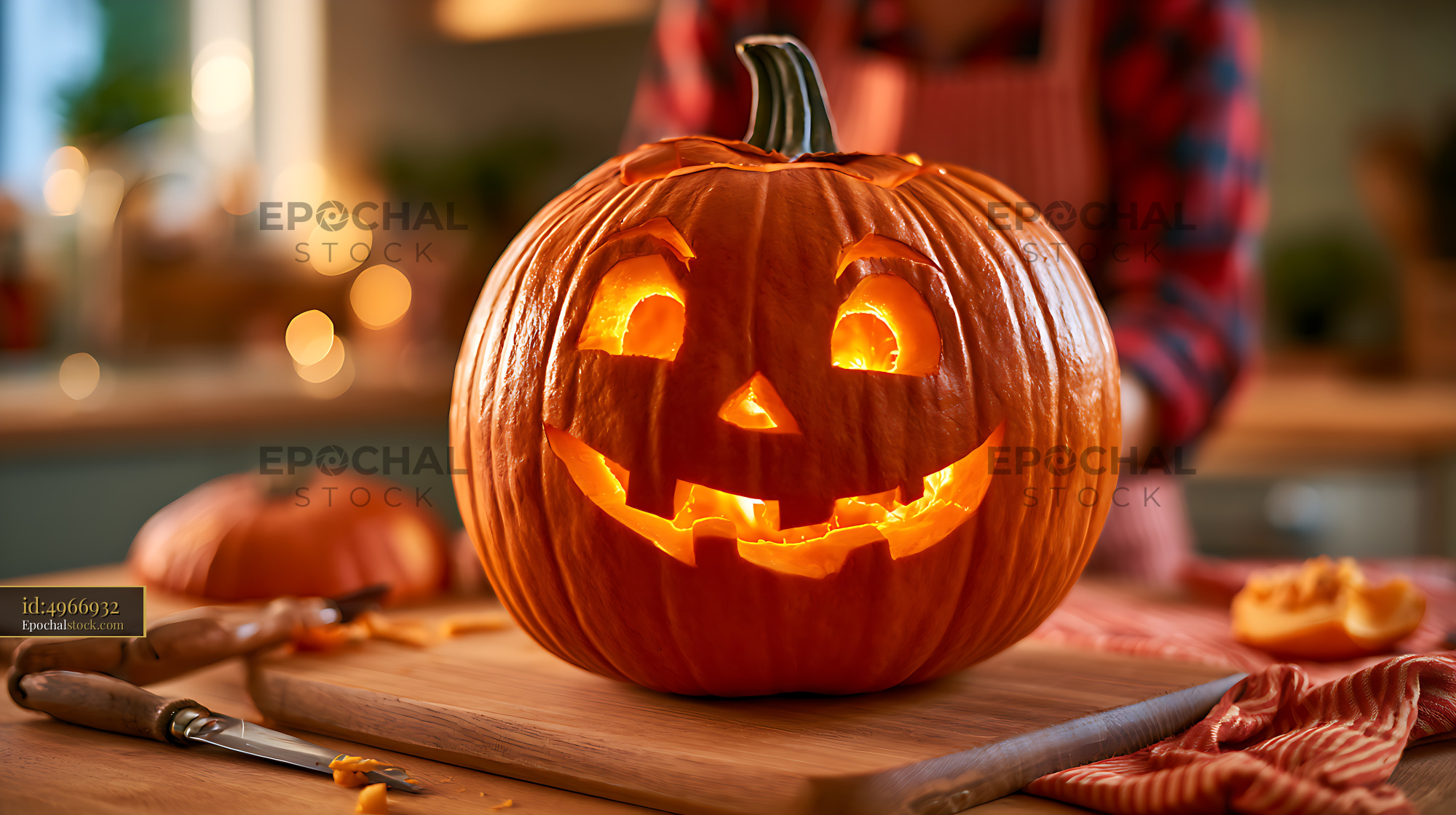 Watermarked full-resolution preview of Illuminated carved pumpkin with carving tools