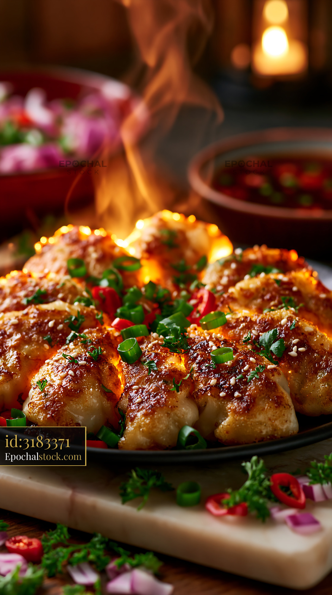 Watermarked full-resolution preview of Delicious dumplings served on a hot plate with herbs and sauce