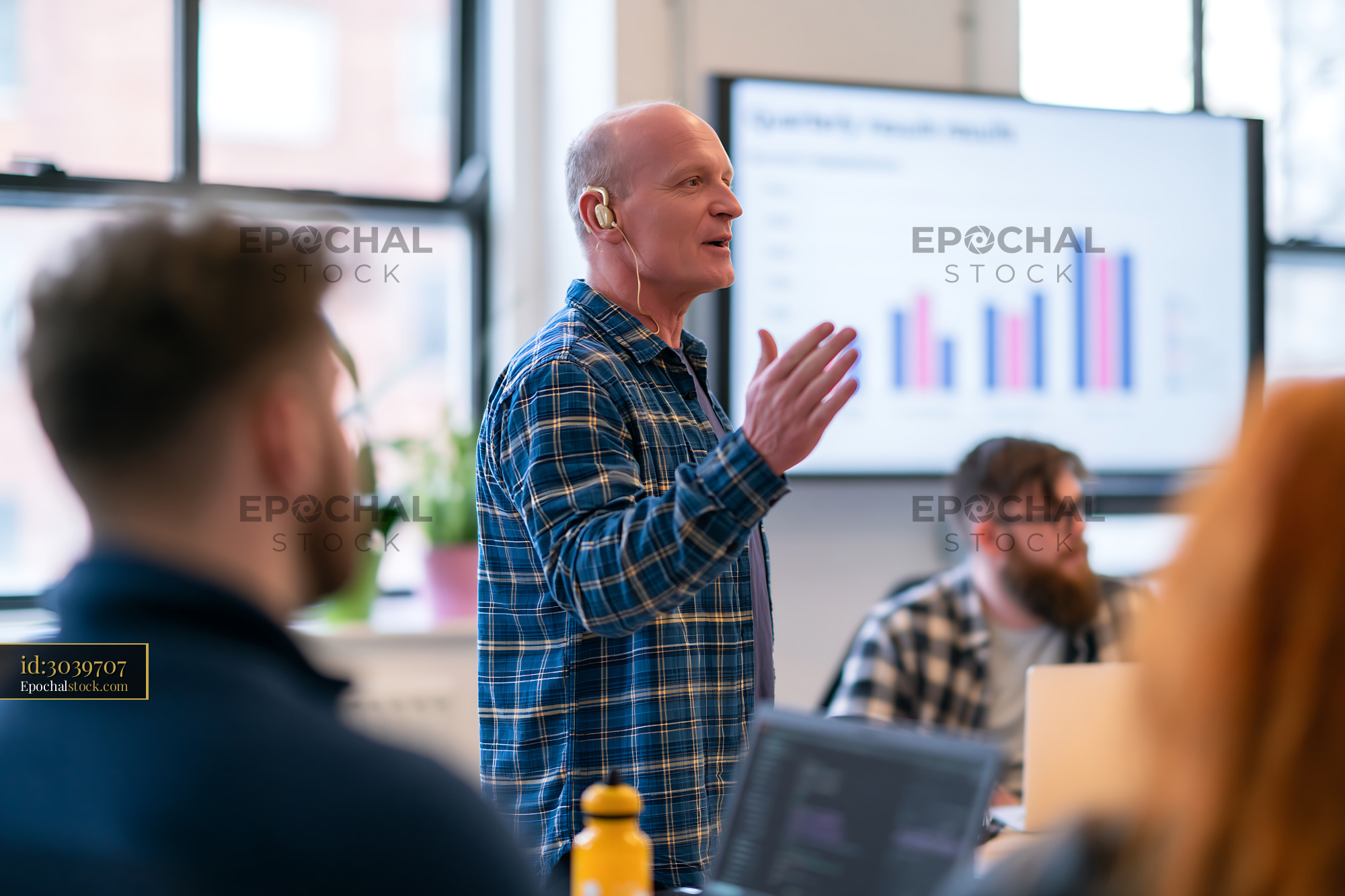 Watermarked full-resolution preview of Business meeting with a speaker presenting data in a modern office