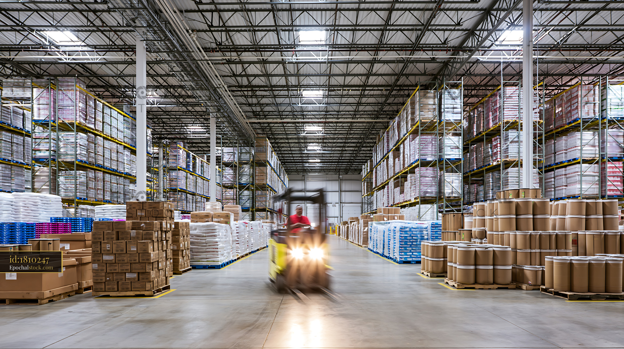 Watermarked full-resolution preview of Warehouse with stacks of goods and a forklift in operation