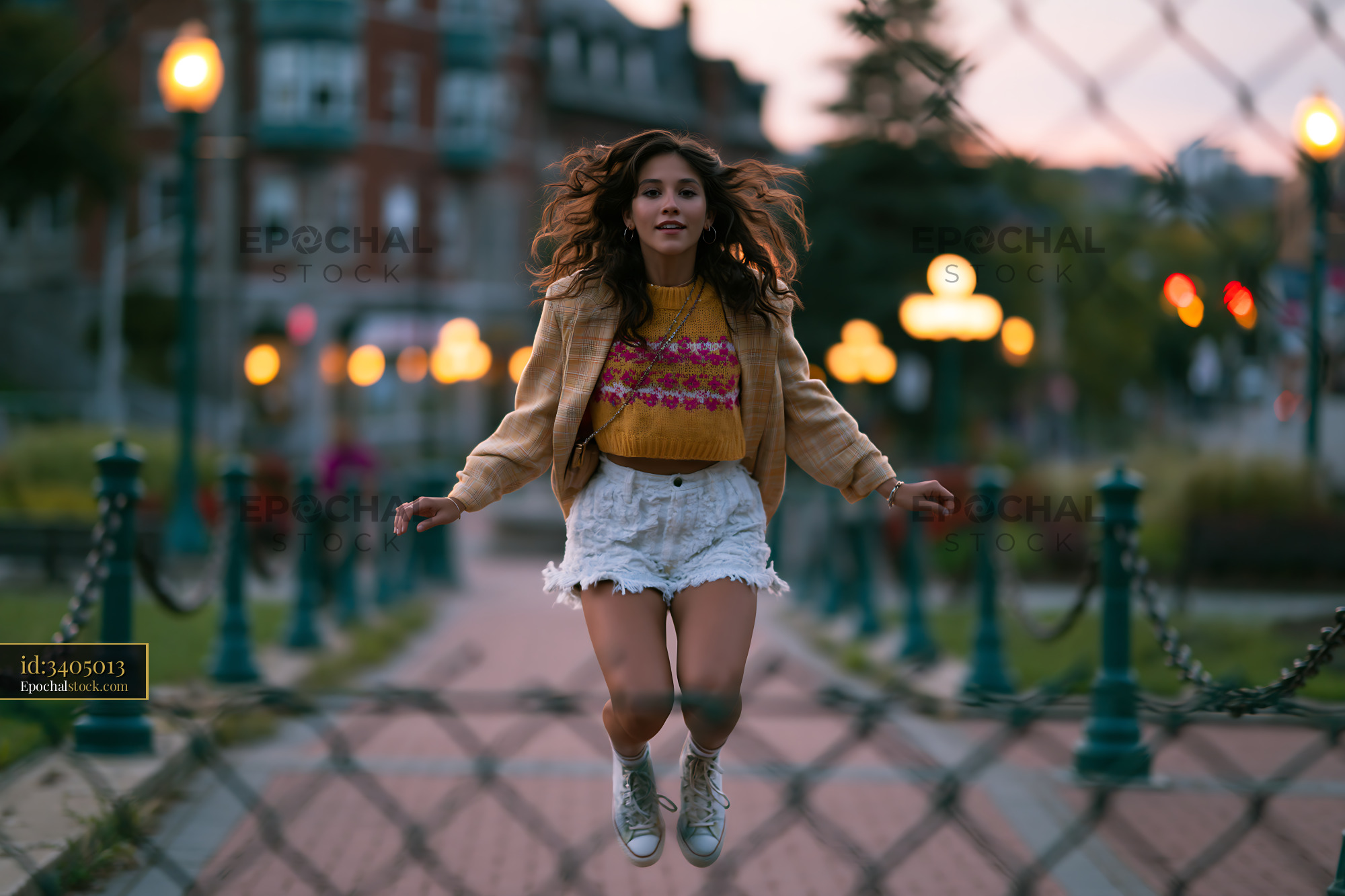 Woman Jumping in Oversized Blazer and Bike Shorts at Sunset - stock photo