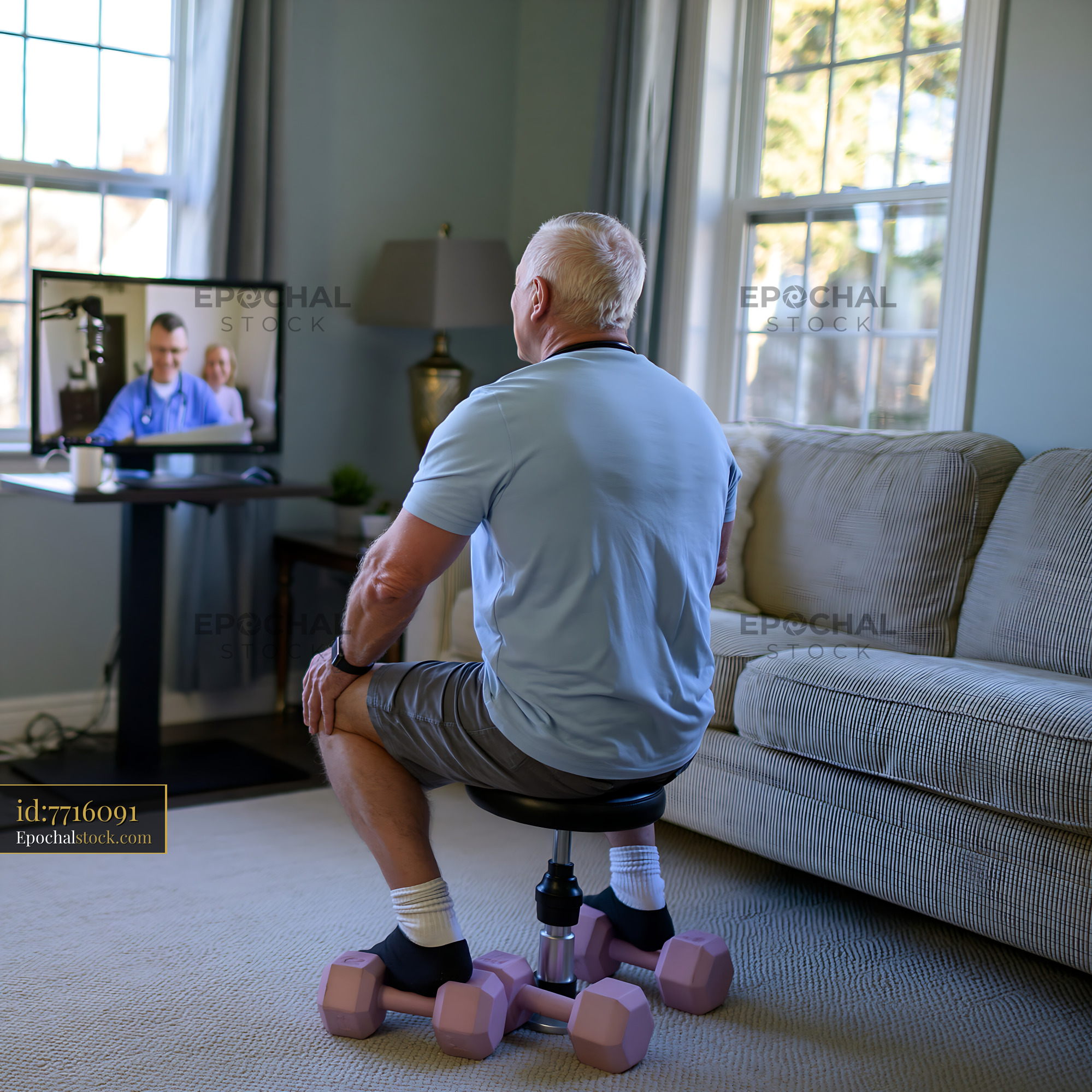 Watermarked full-resolution preview of Senior man watching a telehealth appointment while exercising at home