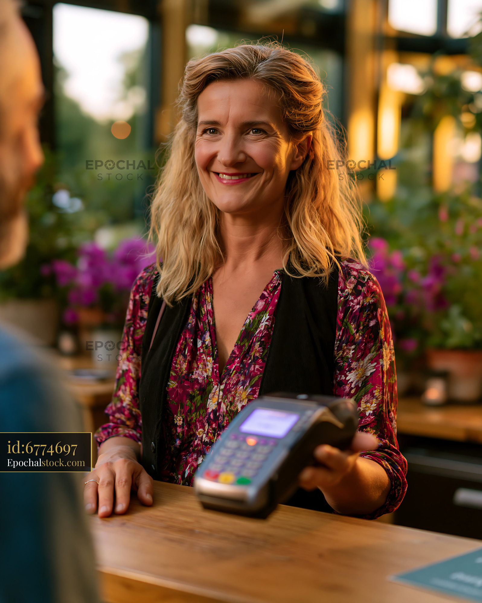 Watermarked full-resolution preview of Cashier assisting customer at a cafe during sunset