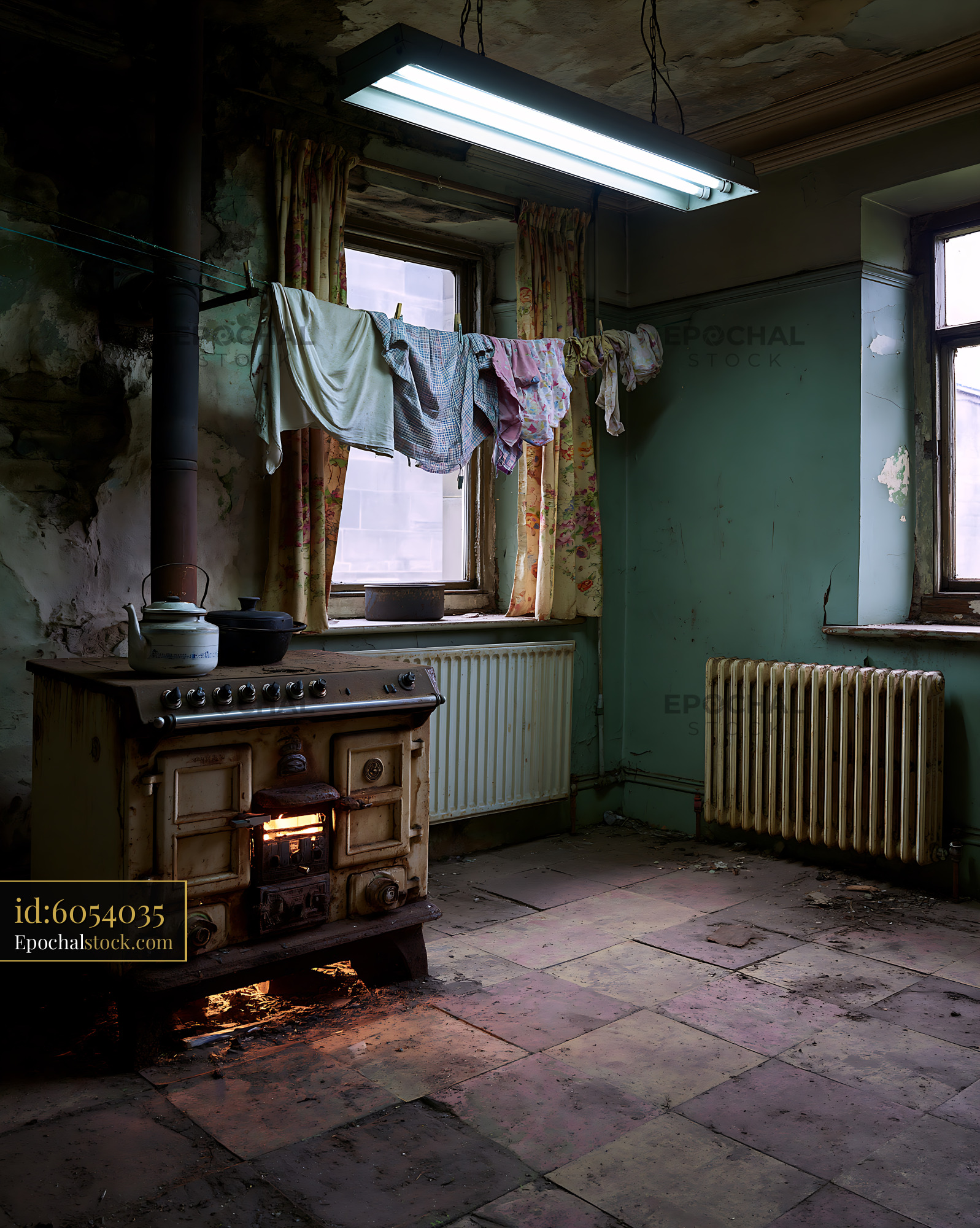Watermarked full-resolution preview of Old kitchen with a stove and hanging clothes in a rundown room