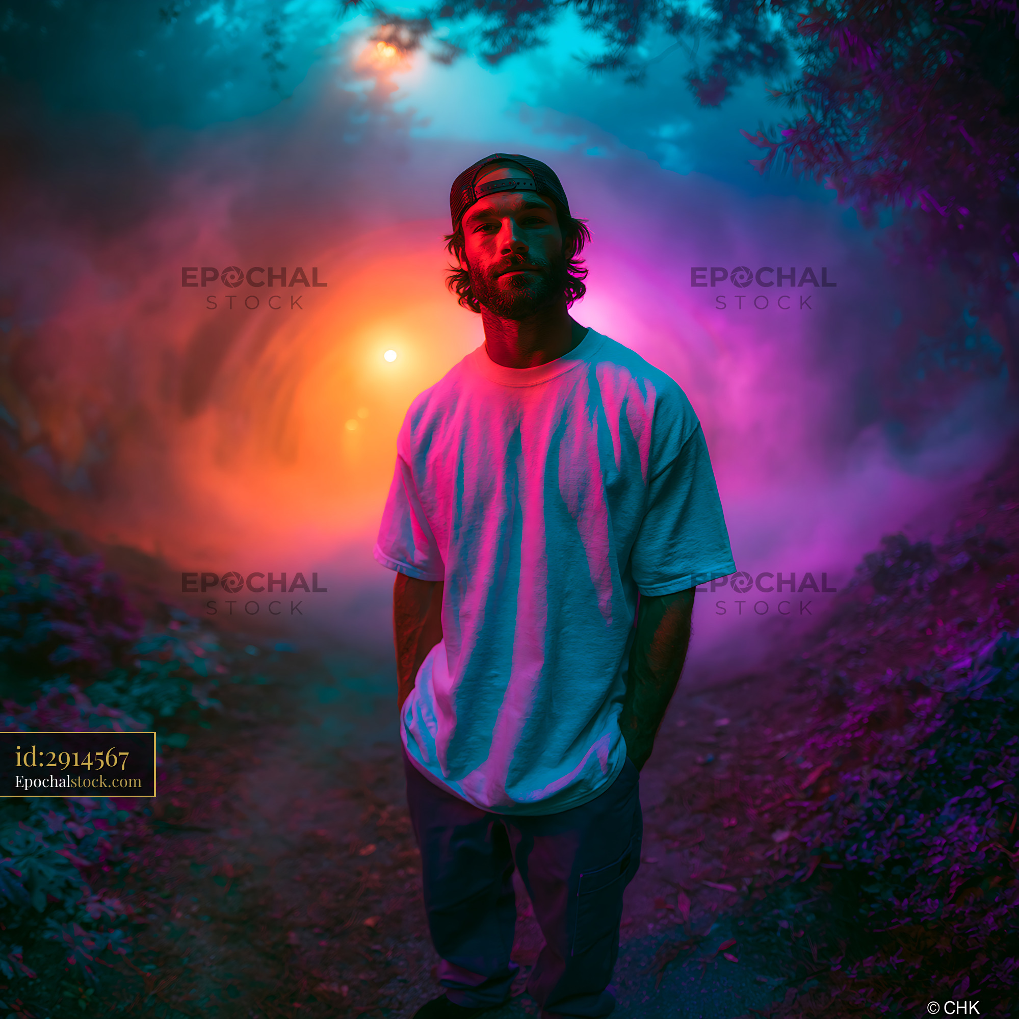 Skater Man Standing in a Colorful Misty Forest Setting - stock photo