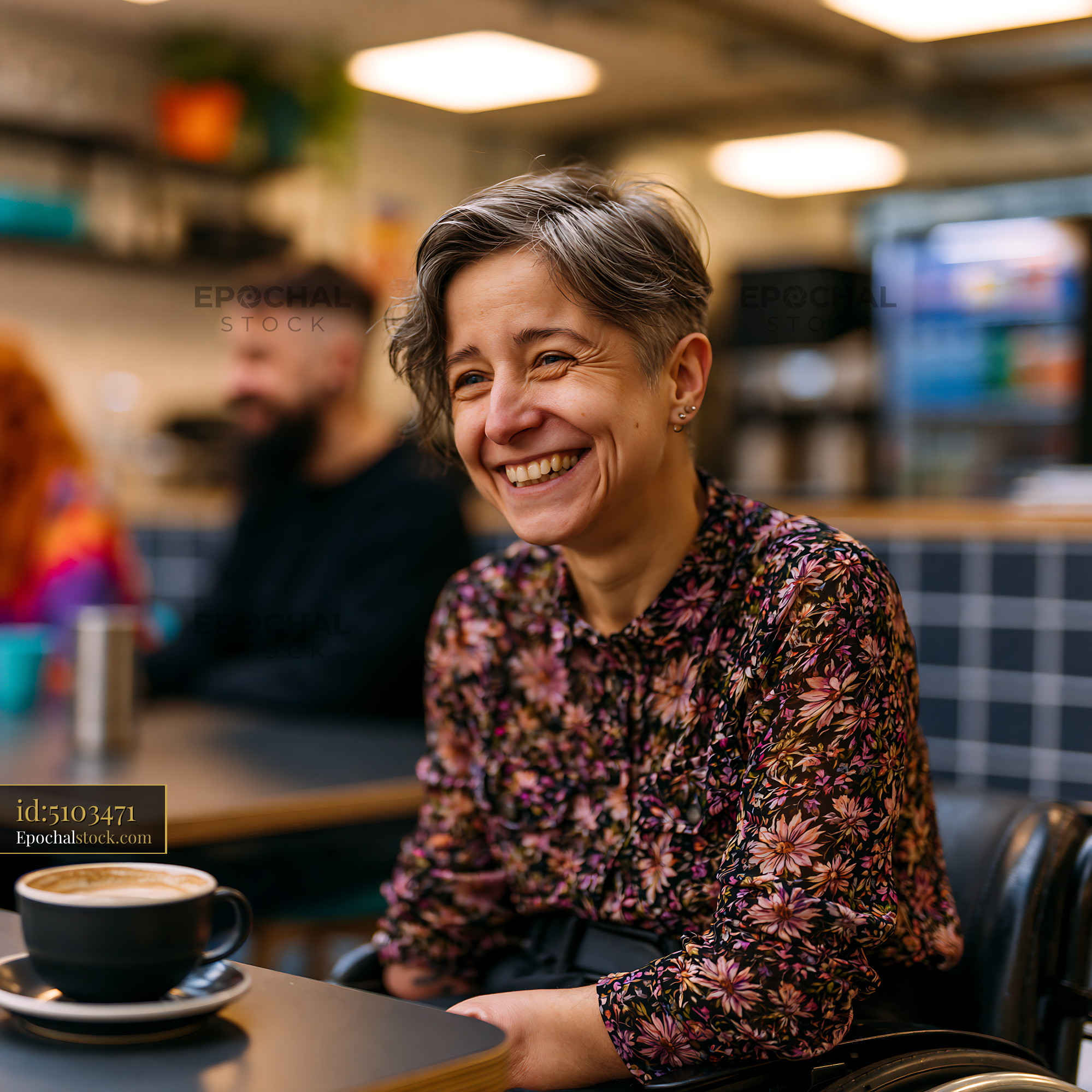 Watermarked full-resolution preview of Woman smiling in a modern cafe with friends in the background