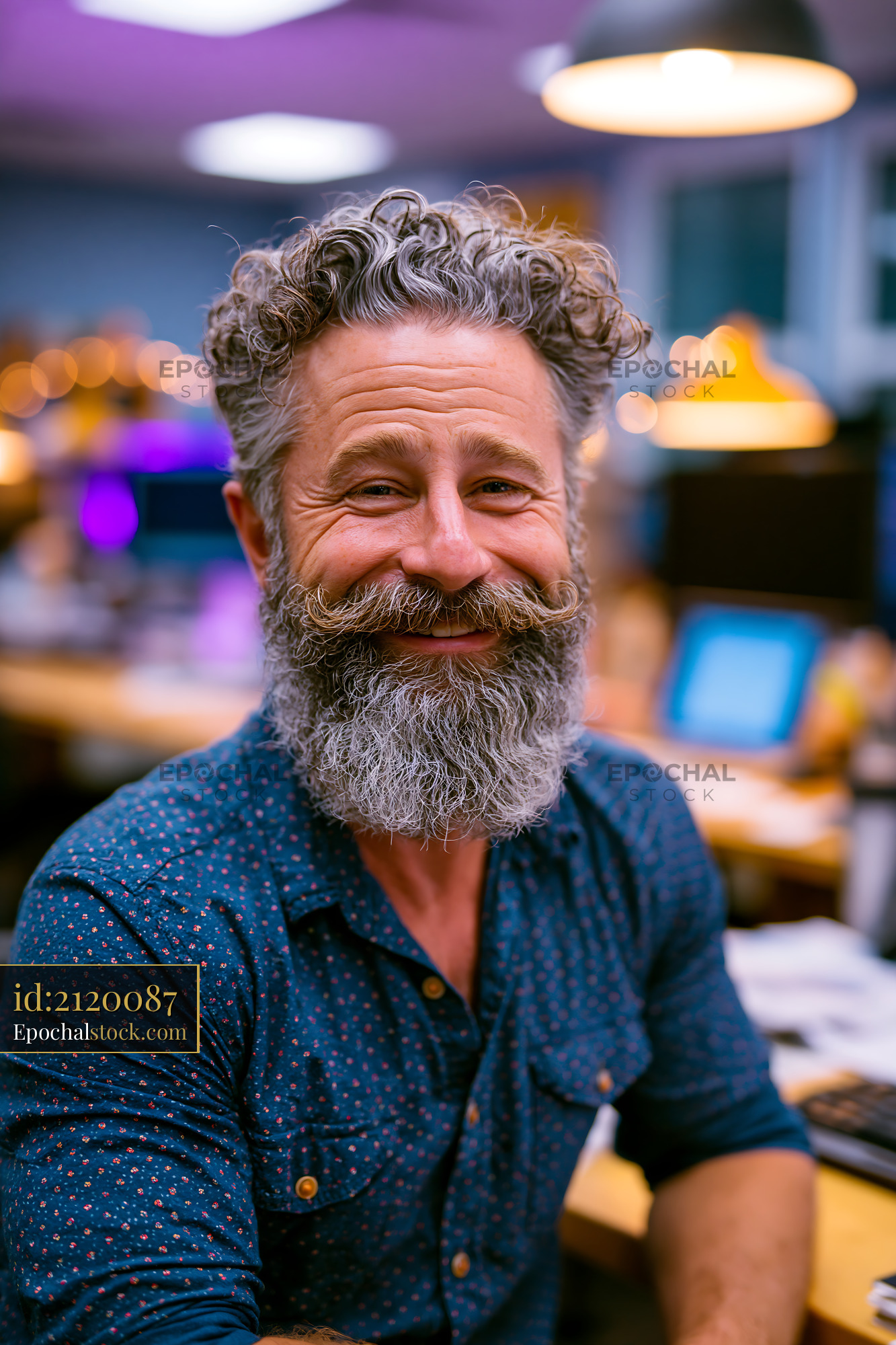 Man With a Beard Seated at a Desk Inside an Office - stock photo