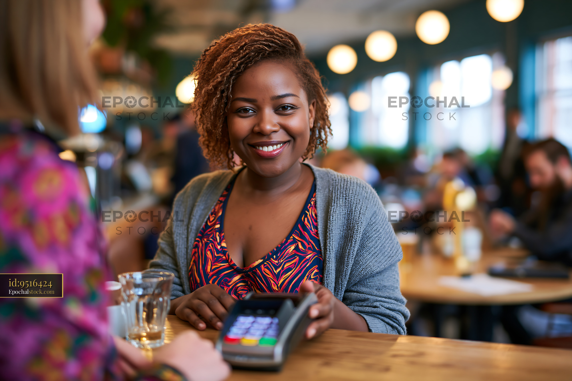 Watermarked full-resolution preview of Smiling woman using a digital payment method in a cafe
