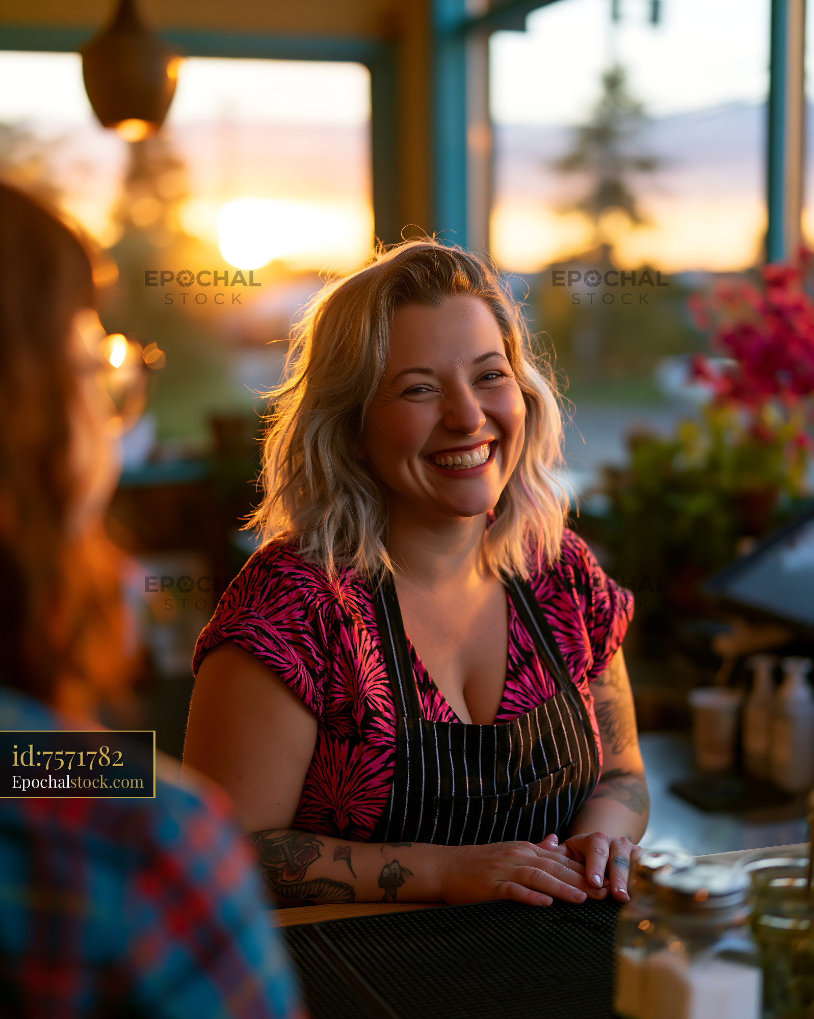 Watermarked full-resolution preview of Woman smiling at a counter in a cafe during sunset