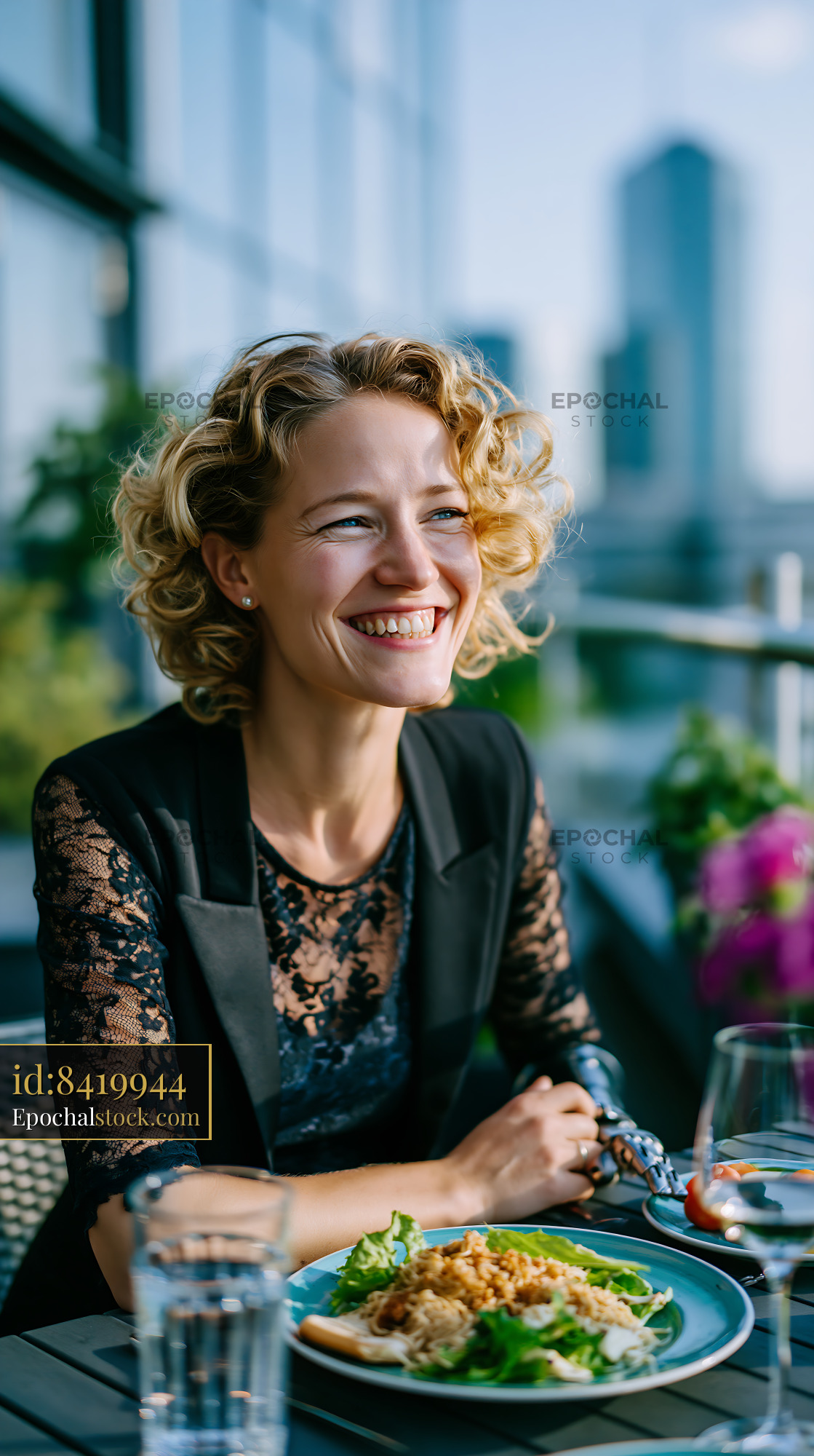 Watermarked full-resolution preview of Woman enjoying meal at outdoor restaurant with city view