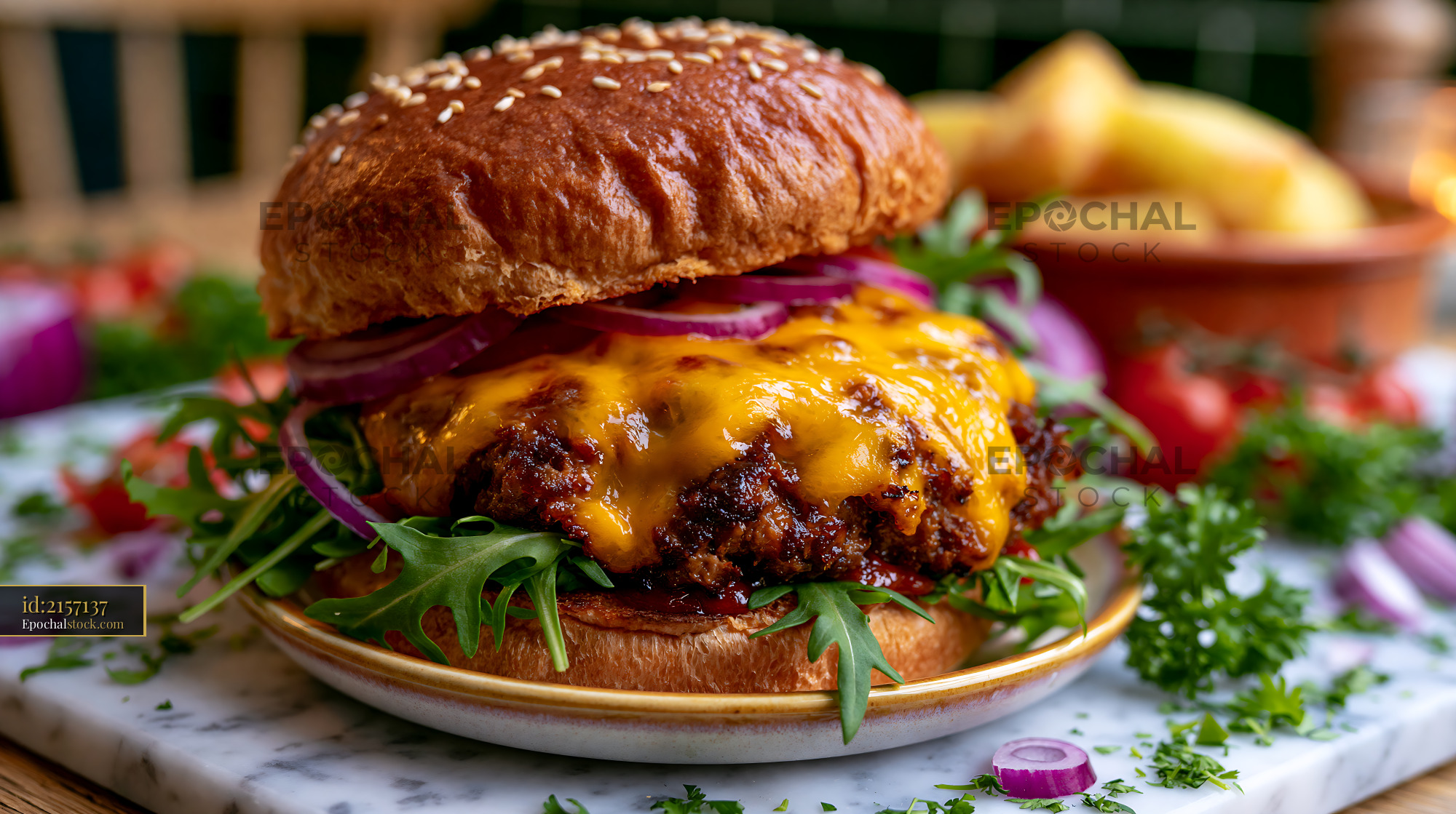 Watermarked full-resolution preview of Juicy cheeseburger served with fries on a wooden table