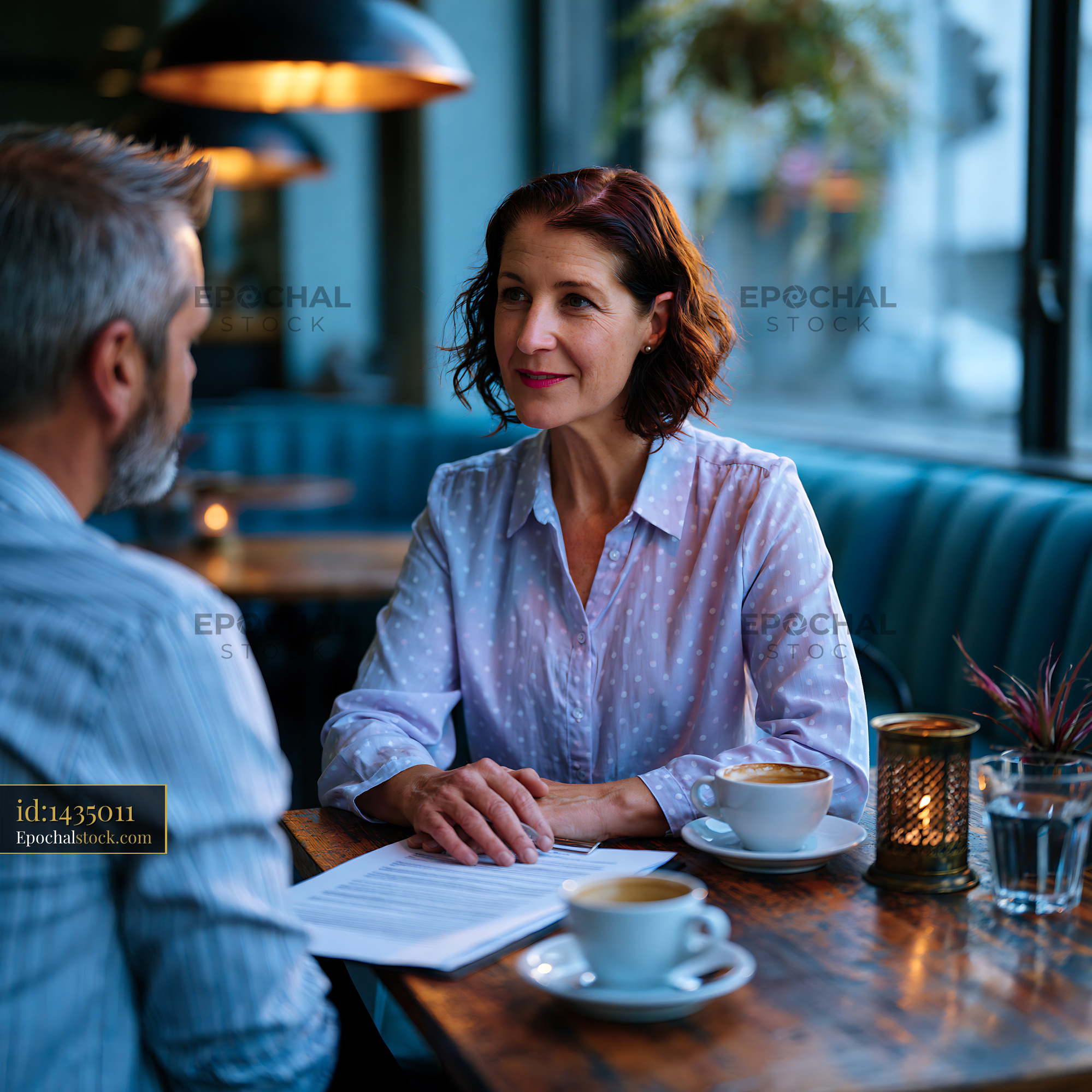 Watermarked full-resolution preview of Business meeting in a coffee shop with two people talking
