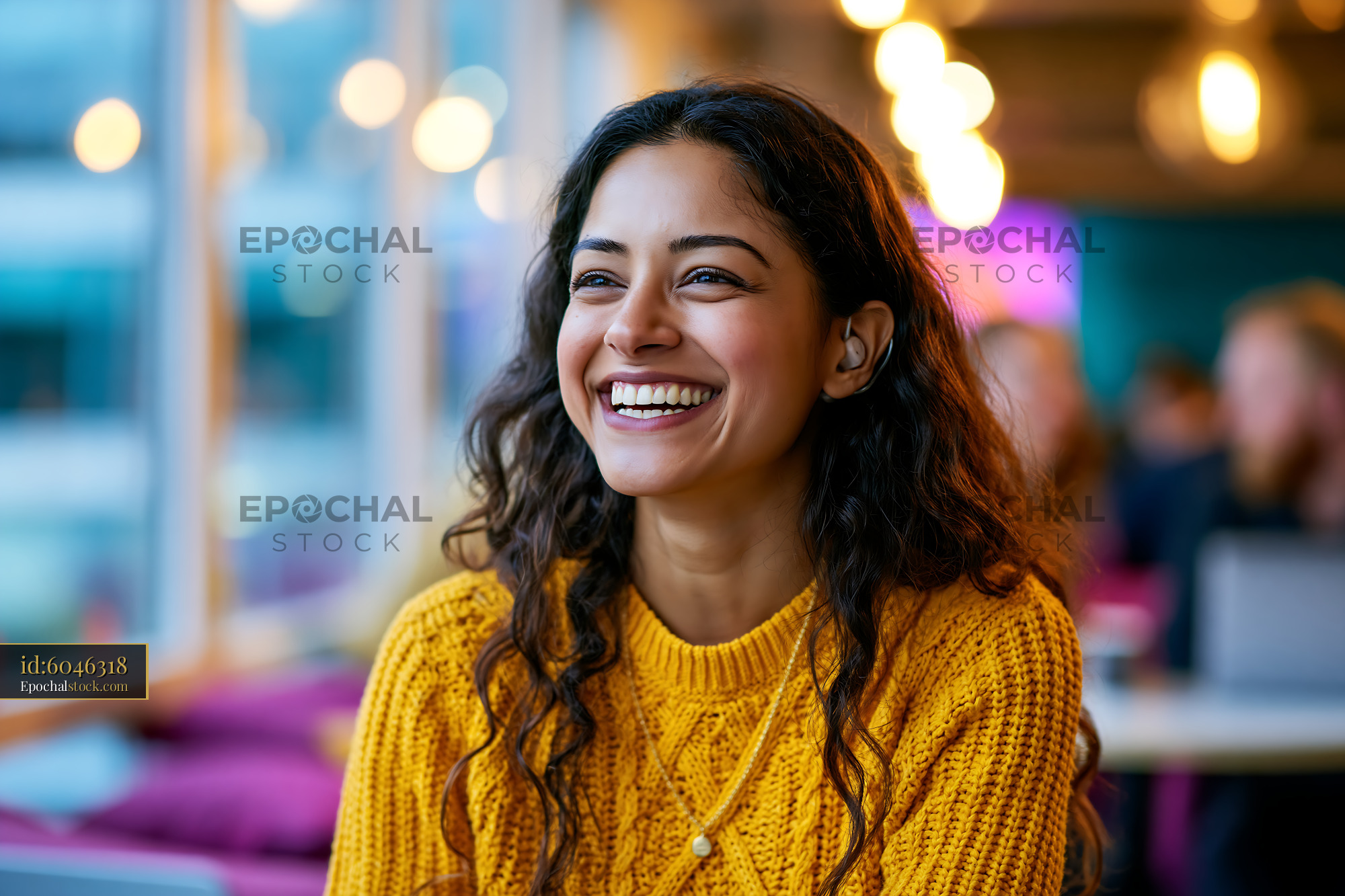 Watermarked full-resolution preview of Woman smiles in a cafe with warm lights during daytime