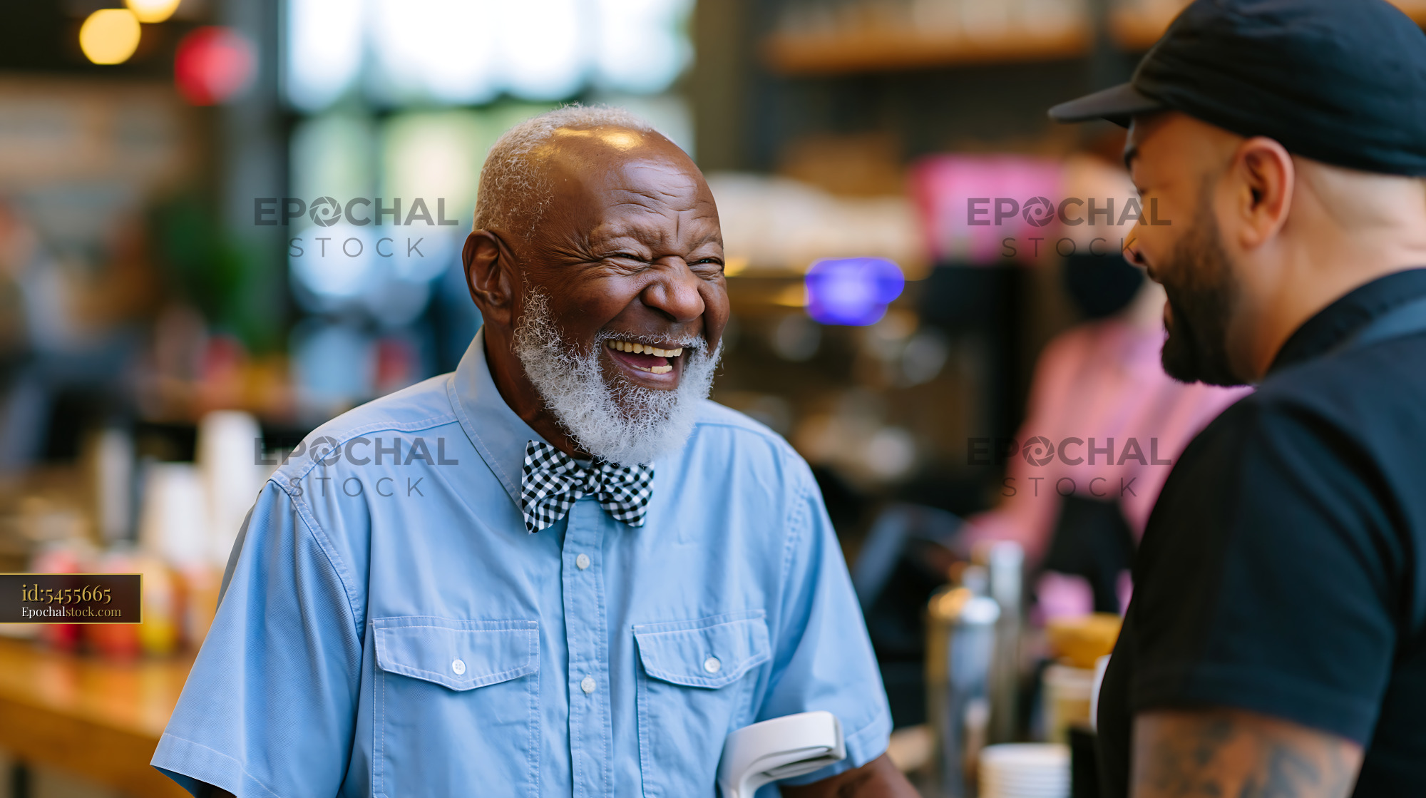 Watermarked full-resolution preview of Two men talking at a cafe with smiles in a lively setting