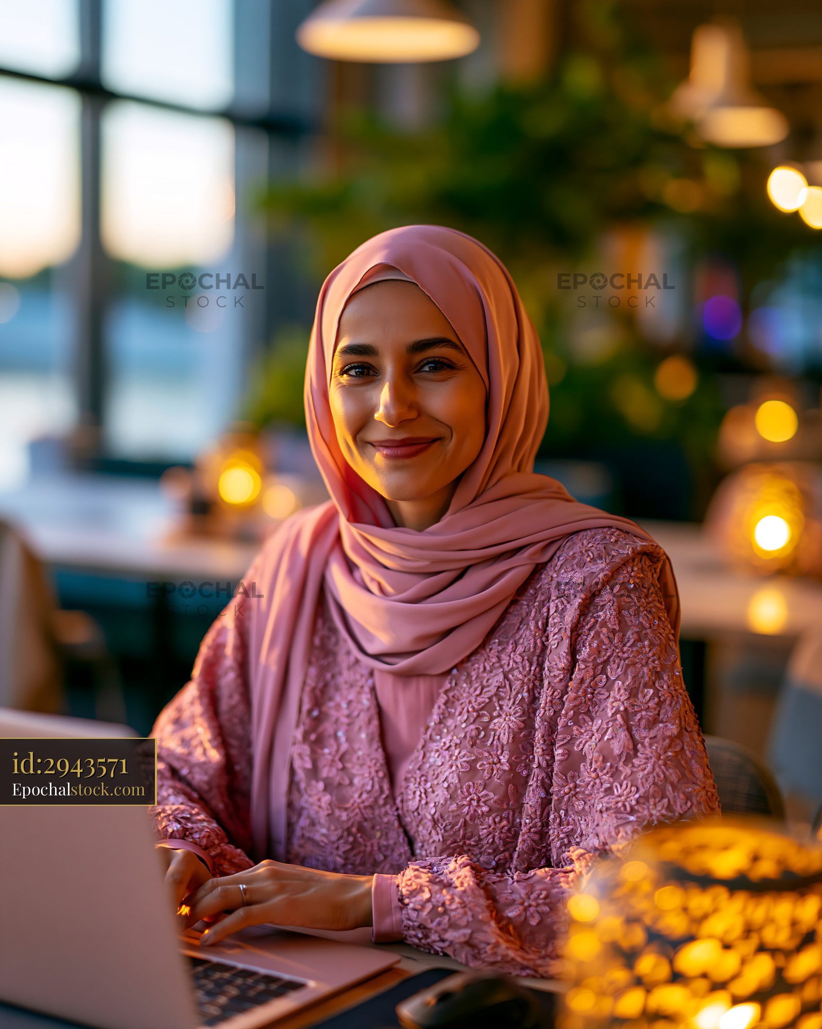 Watermarked full-resolution preview of Woman working on a laptop in a cozy cafe during sunset