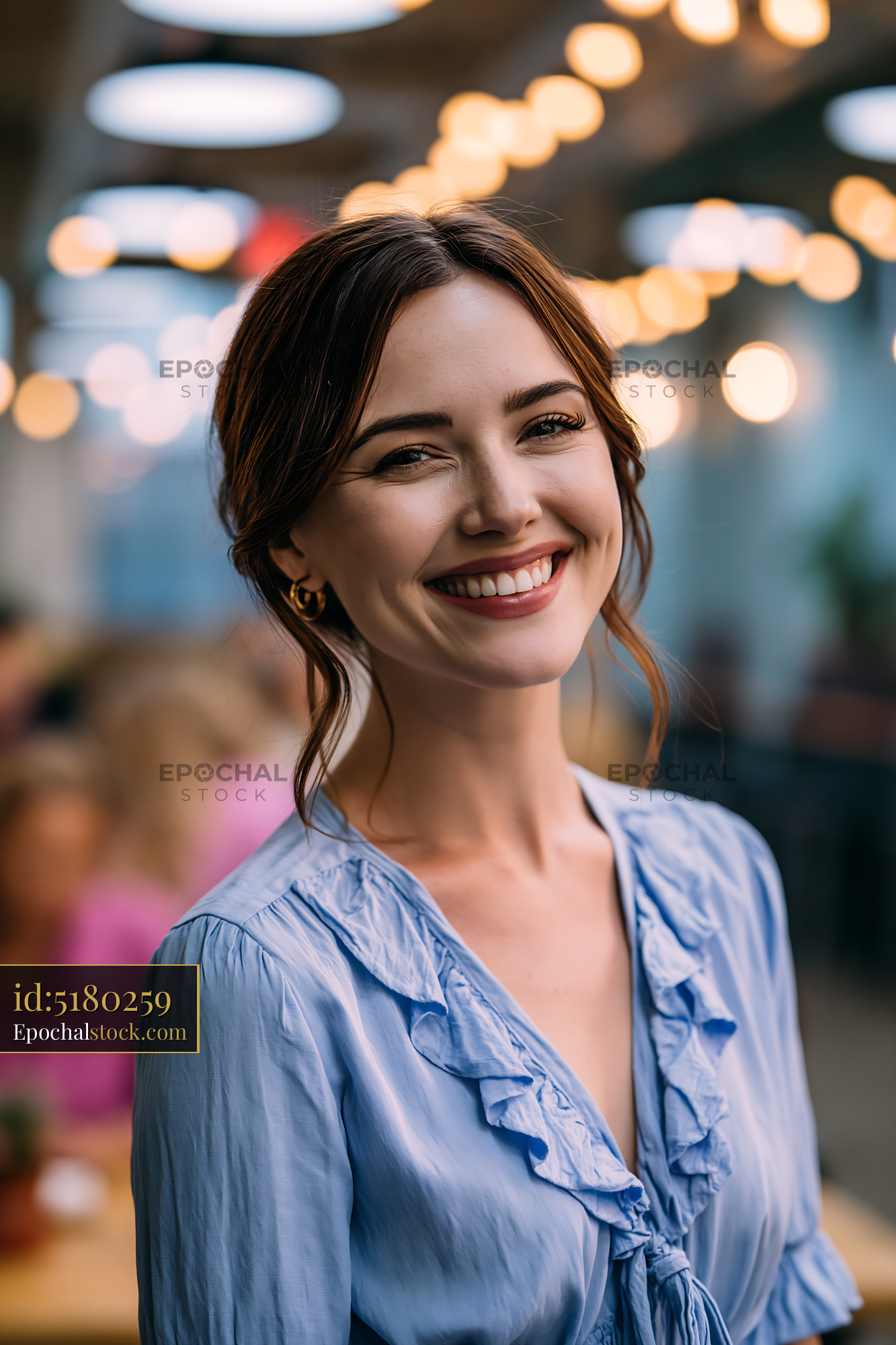 Watermarked full-resolution preview of Young woman smiling in a cafe with warm light decor