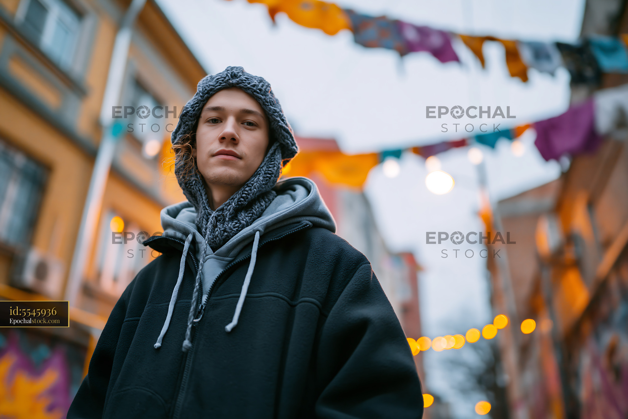 Watermarked full-resolution preview of Young person standing in festive street with decorations
