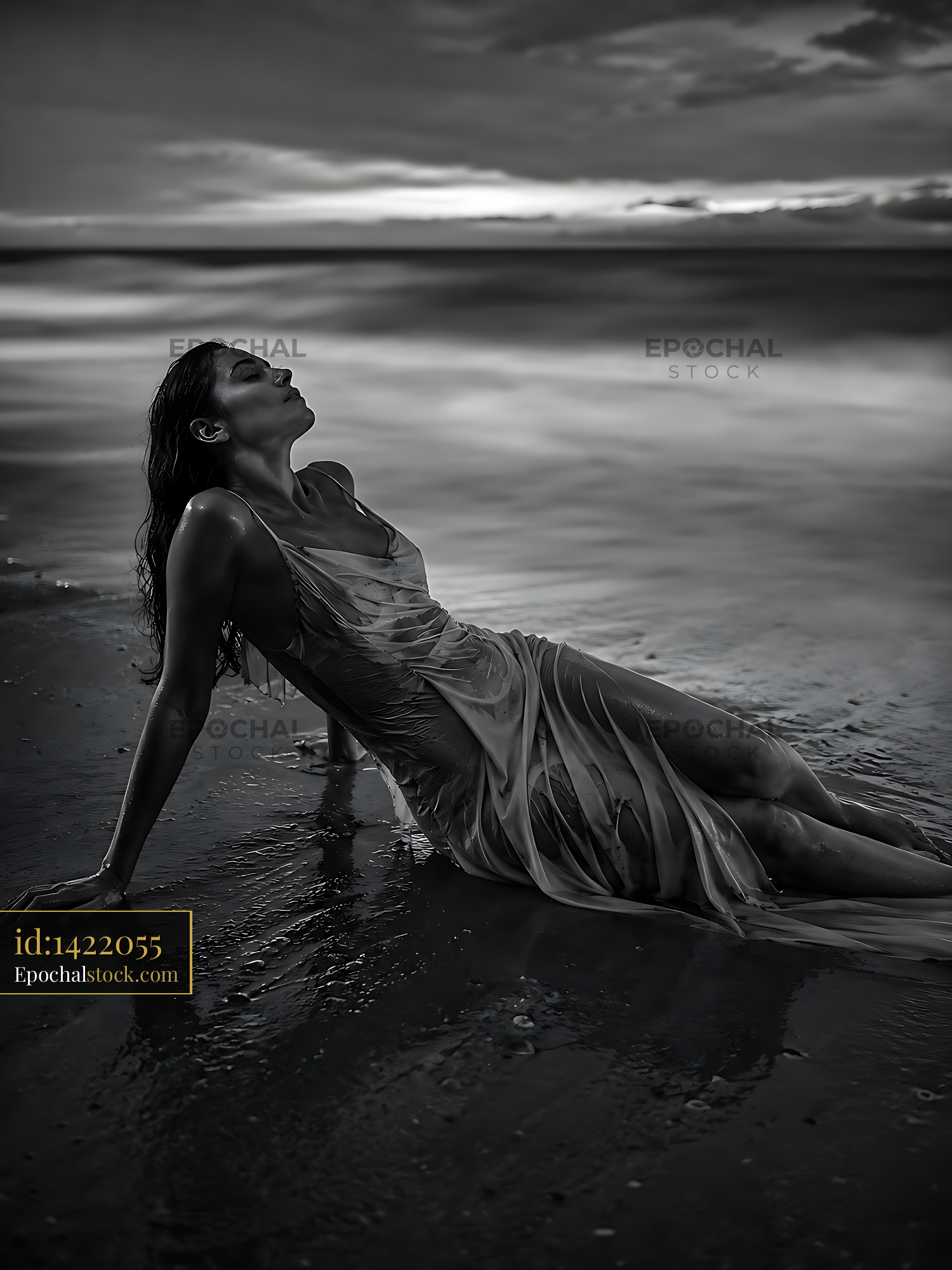 Watermarked full-resolution preview of Woman sitting on wet sand by the ocean at sunset