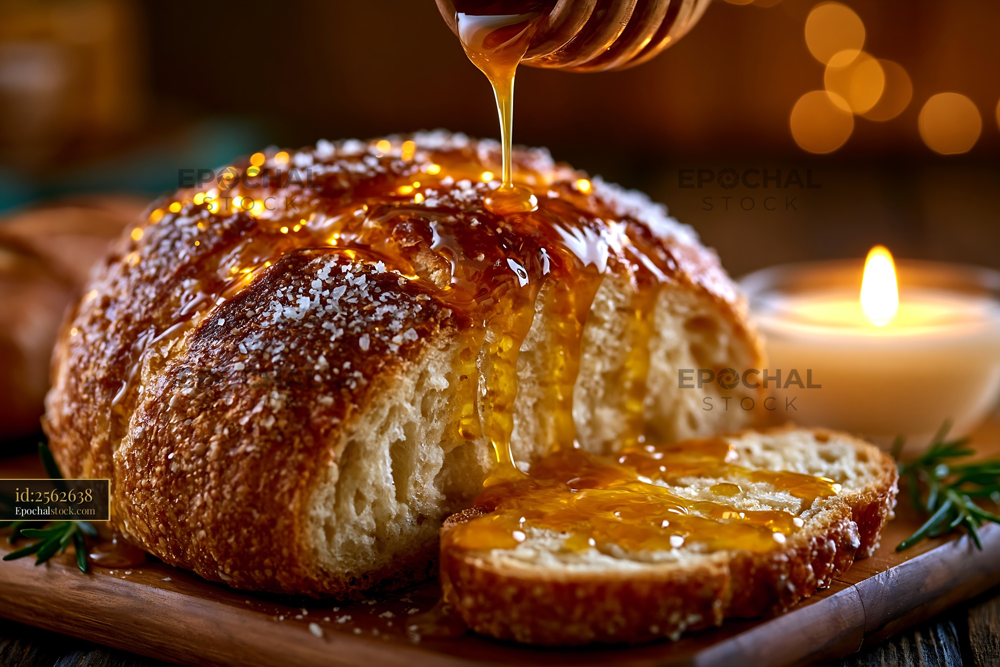 Watermarked full-resolution preview of Freshly baked bread with honey drizzling on top and candlelight