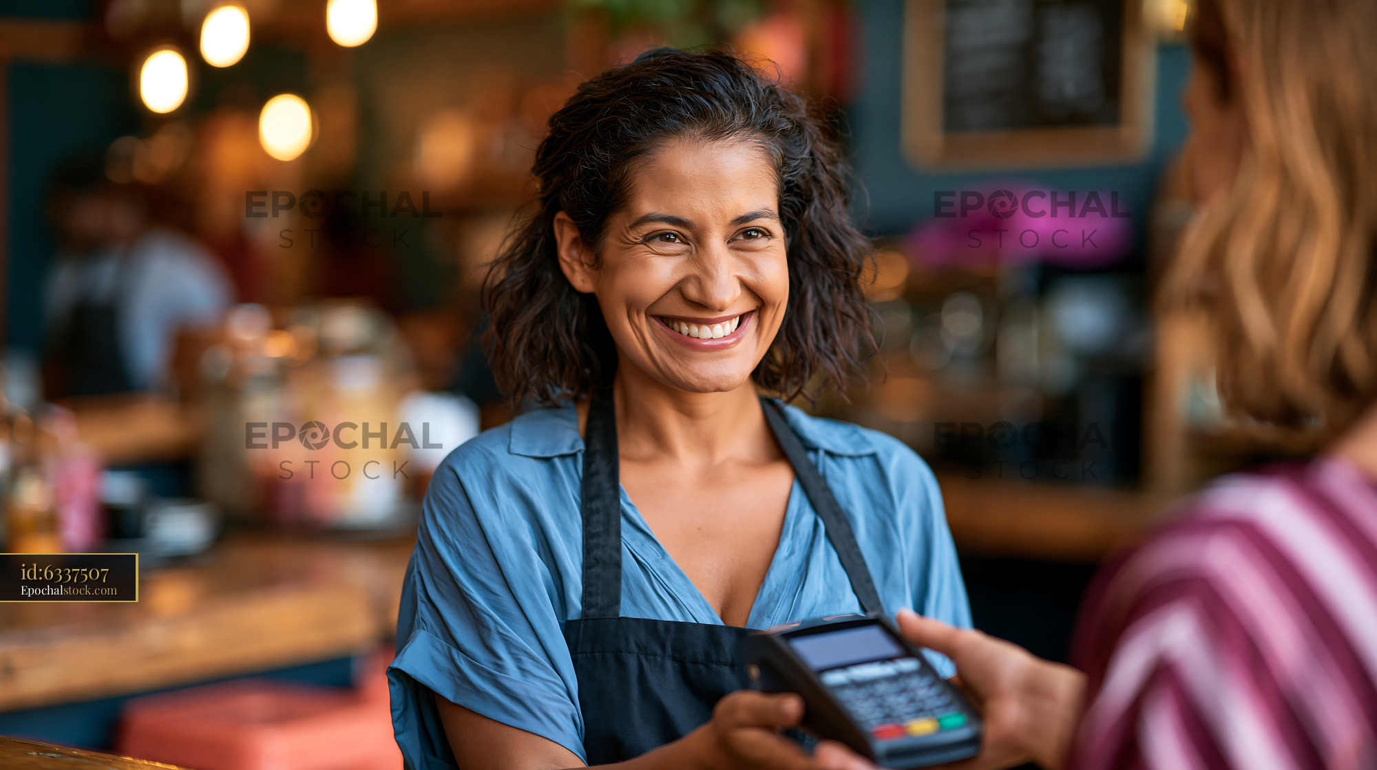 Watermarked full-resolution preview of Happy woman serving customer at cafe with payment device