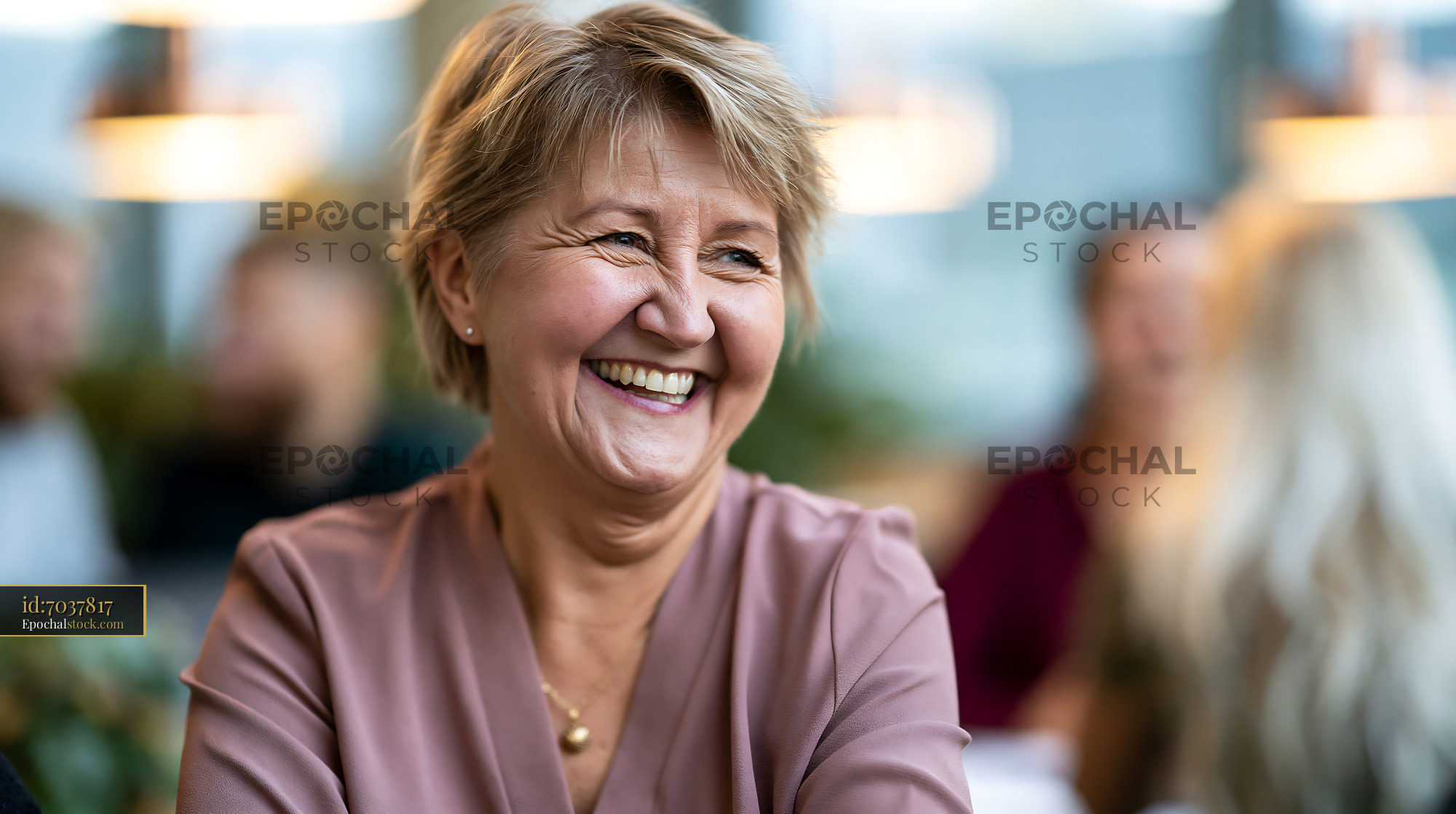 Watermarked full-resolution preview of Joyful mature woman smiling indoors