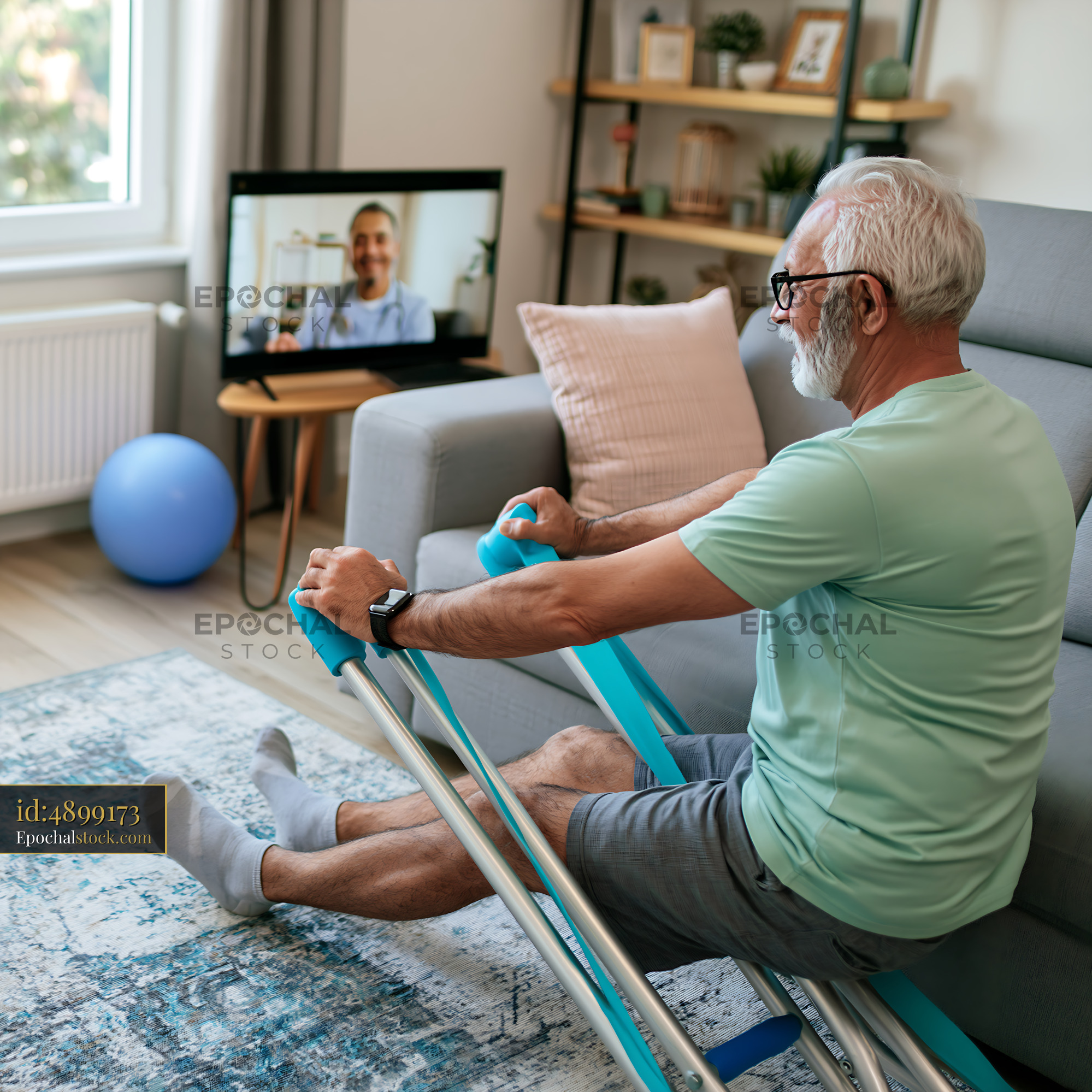 Watermarked full-resolution preview of Senior man exercising at home while watching video on TV