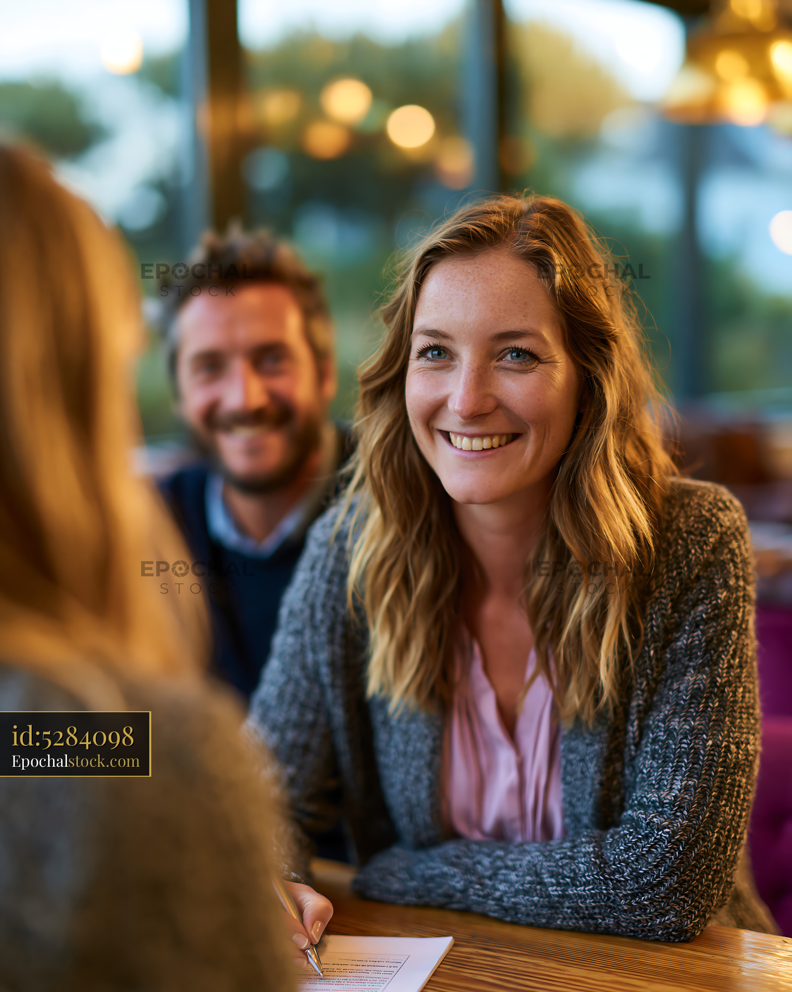 Watermarked full-resolution preview of Happy woman enjoying a café conversation