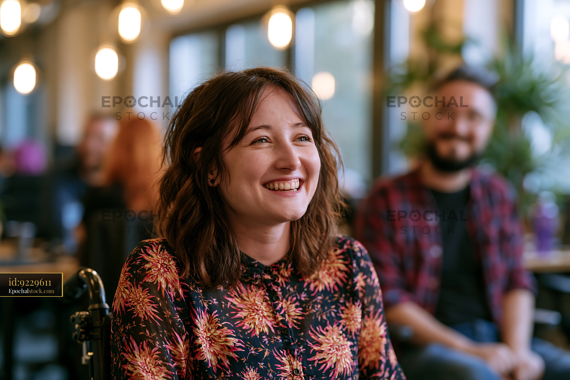 Watermarked full-resolution preview of Smiling woman in a cafe with friends during a social gathering
