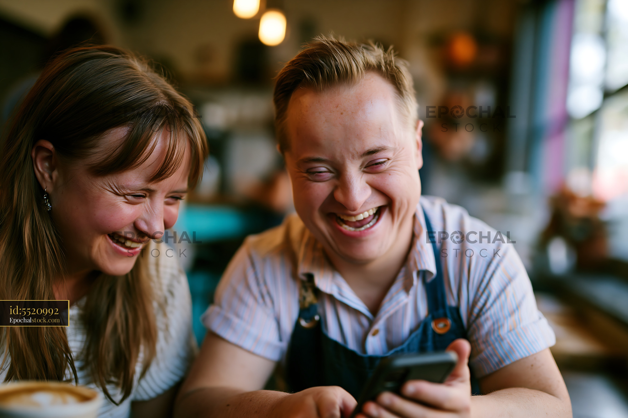 Watermarked full-resolution preview of Two people laughing while looking at a phone in a cafe