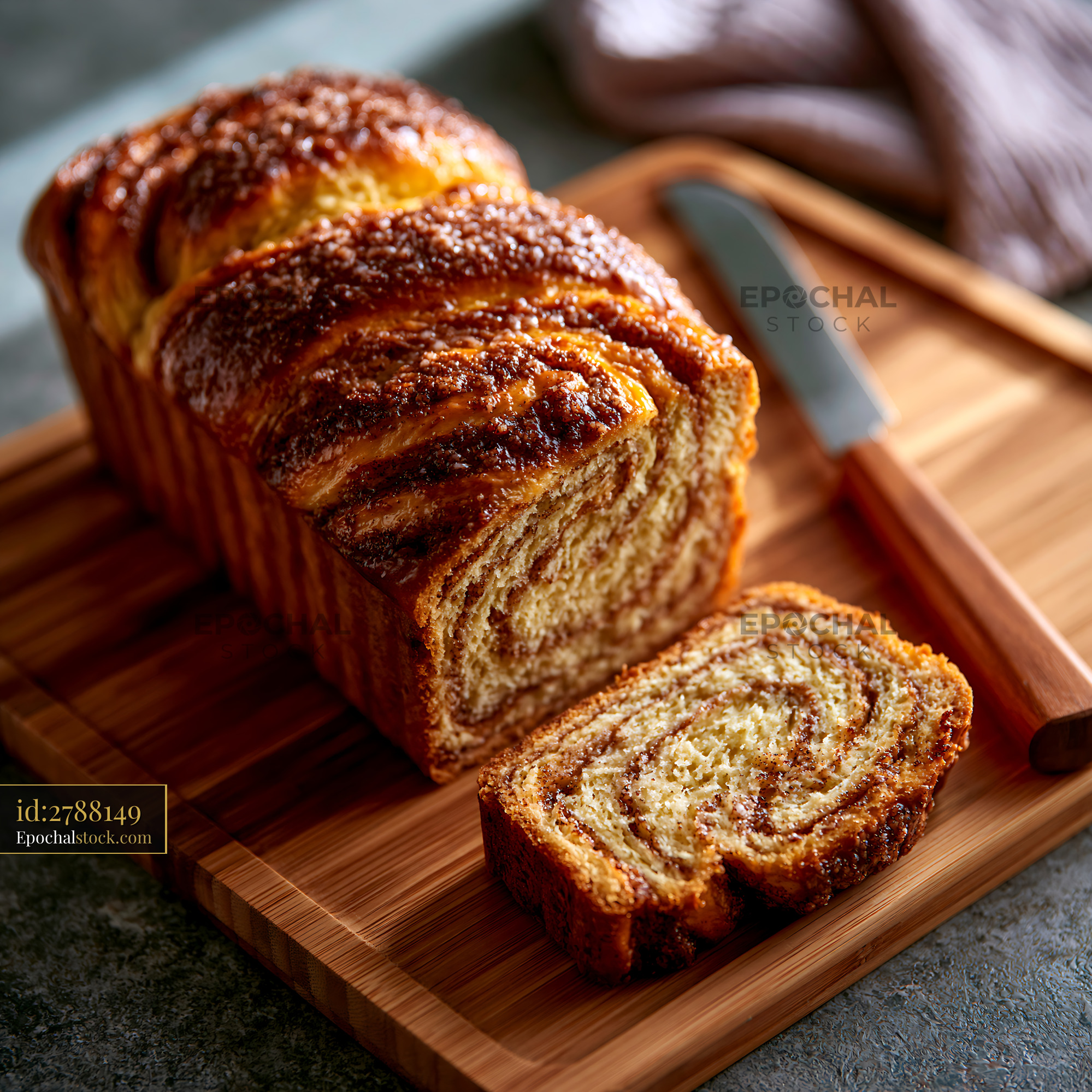 Watermarked full-resolution preview of Freshly baked bread on a wooden board with a knife