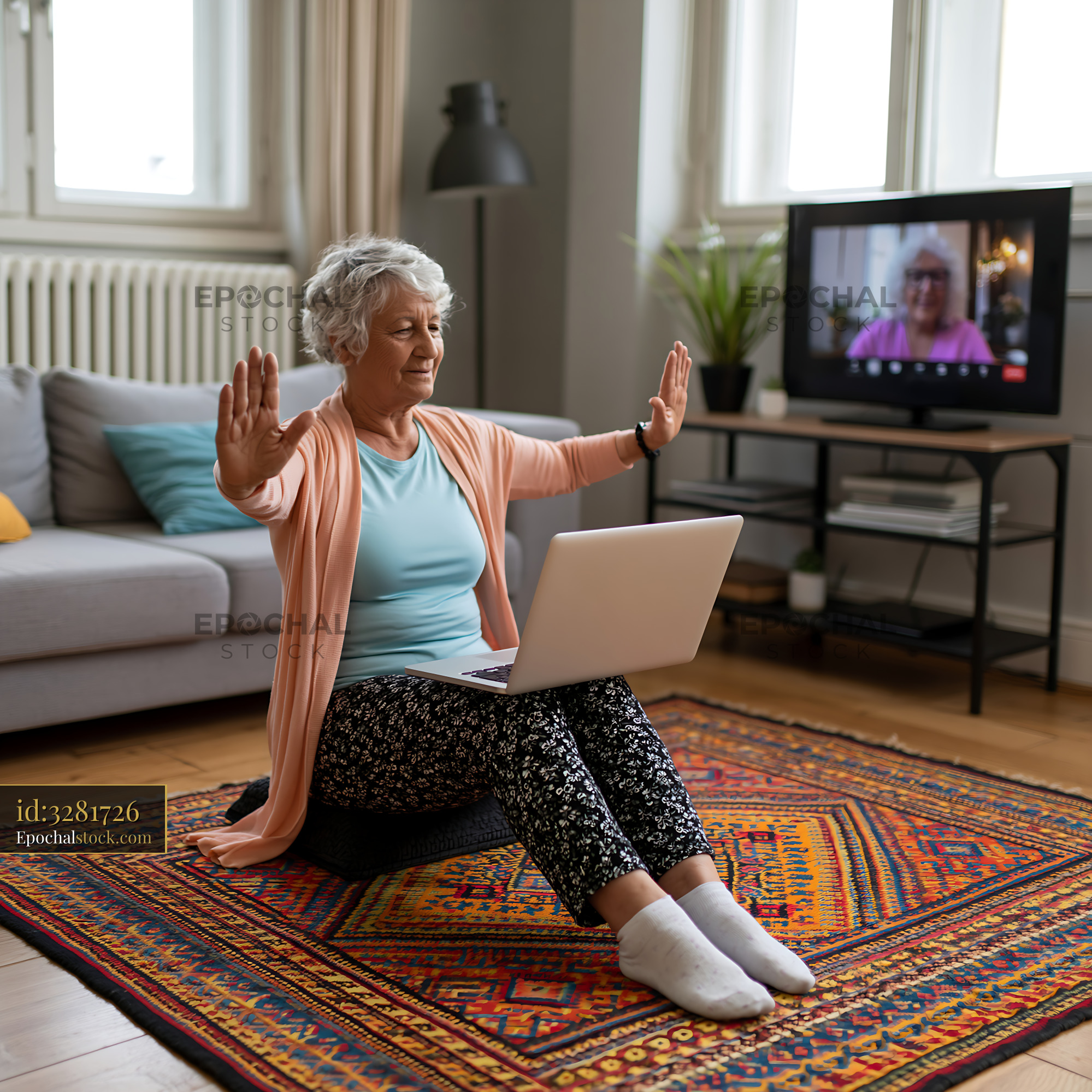 Watermarked full-resolution preview of Older woman having a video call on a laptop while seated on a rug