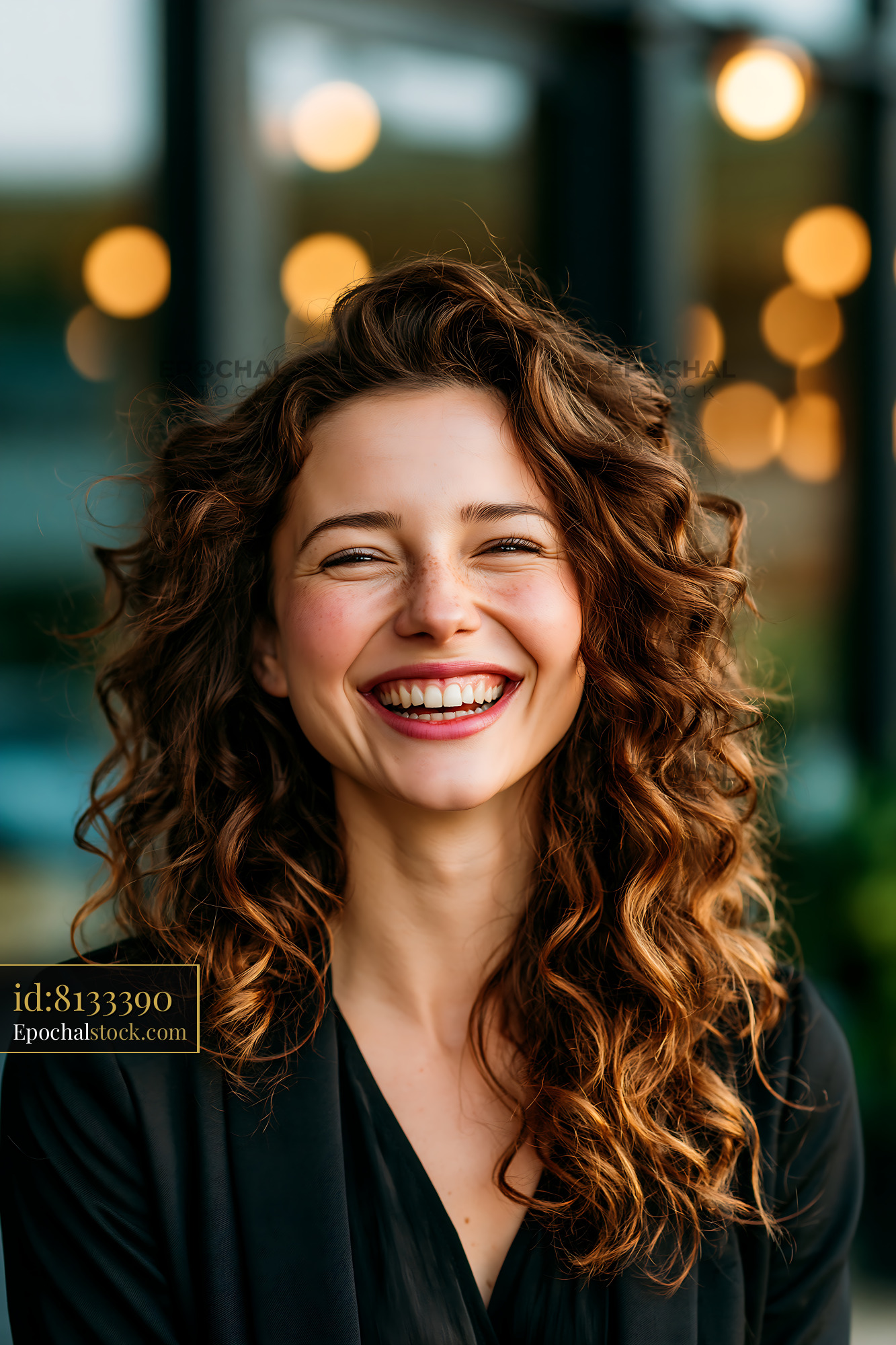 Watermarked full-resolution preview of Woman smiling in a cafe with warm lights in the background
