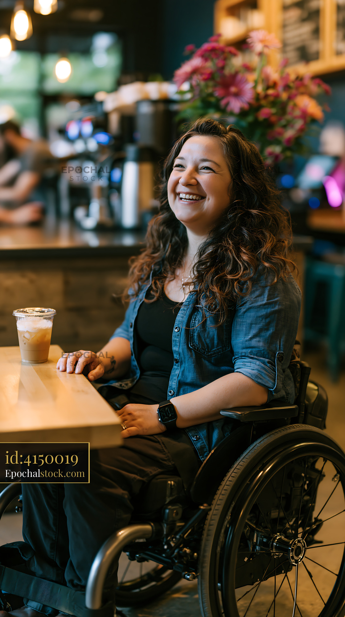 Watermarked full-resolution preview of Woman in wheelchair enjoying coffee in a modern cafe