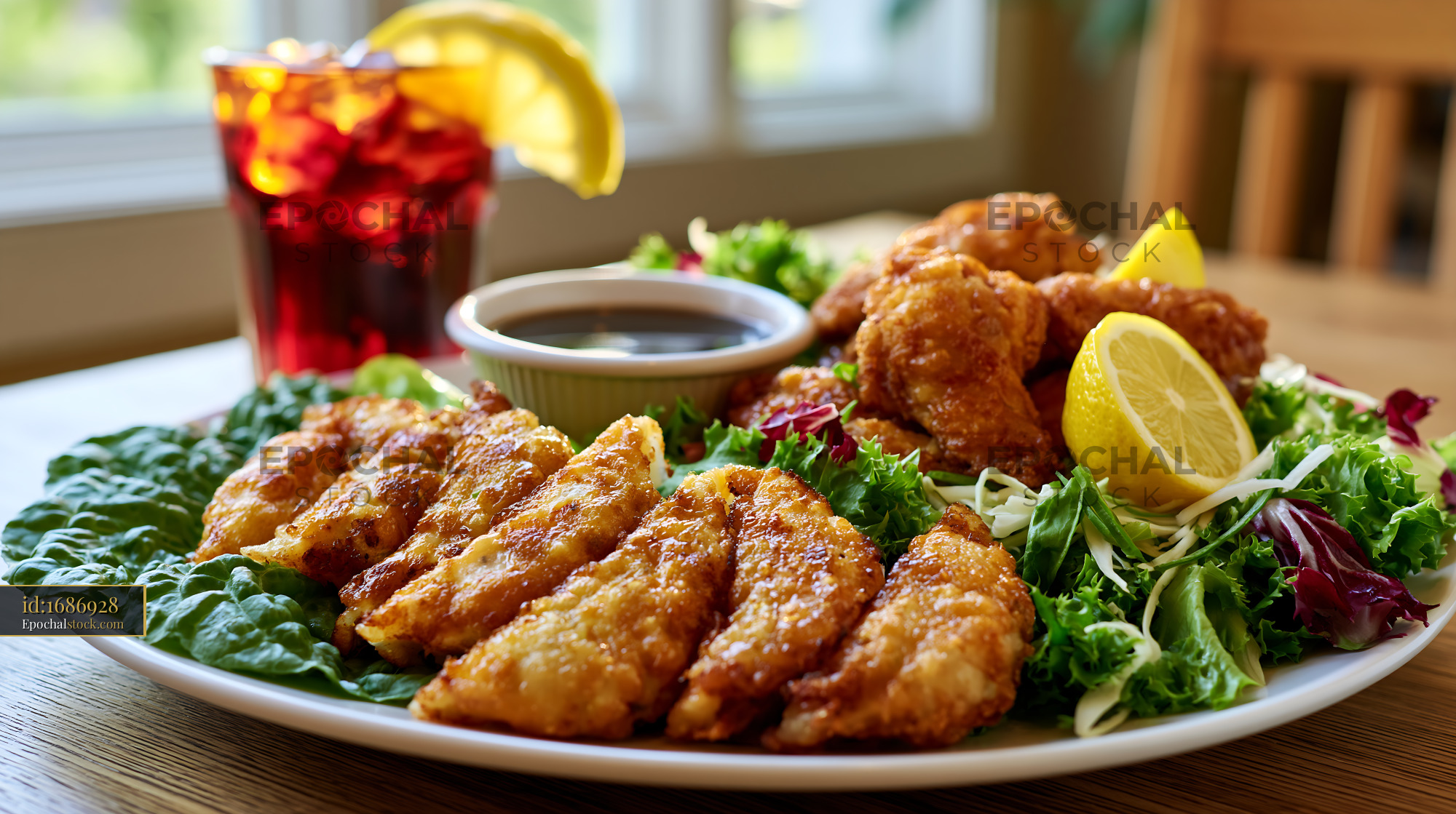 Watermarked full-resolution preview of Fried chicken and fish served with salad and beverages on a table