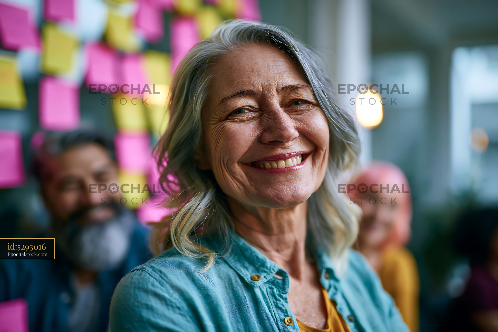 Watermarked full-resolution preview of Smiling older woman stands in front of colorful sticky notes