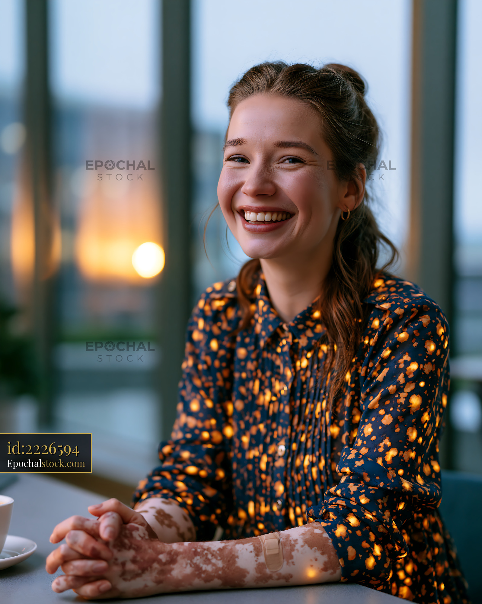 Watermarked full-resolution preview of Joyful woman smiling at a table indoors