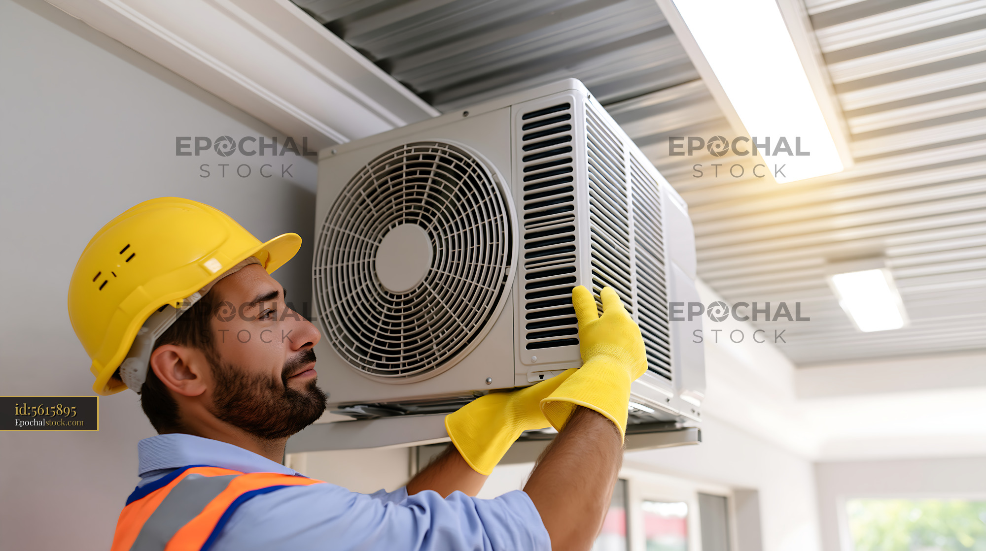 Watermarked full-resolution preview of Man installing air conditioning unit indoors in a modern space