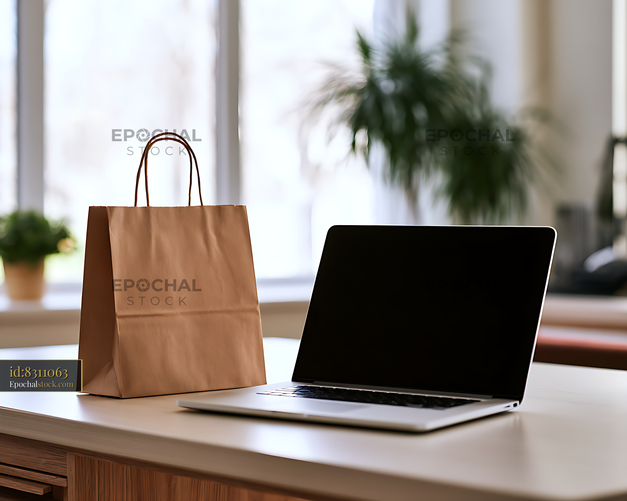 Watermarked full-resolution preview of Paper bag beside an open laptop in a bright interior