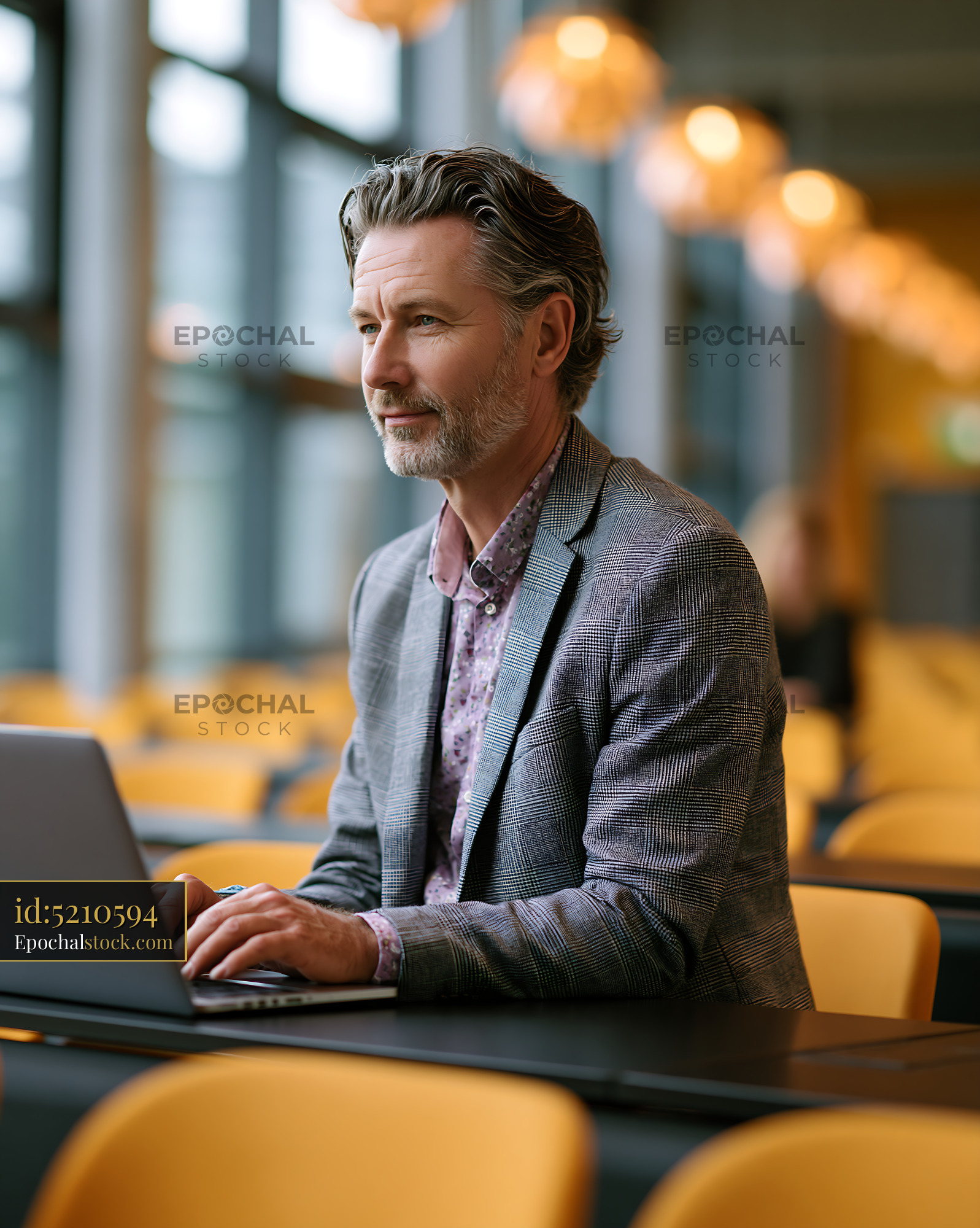 Watermarked full-resolution preview of Professional Man Typing on Laptop at Table